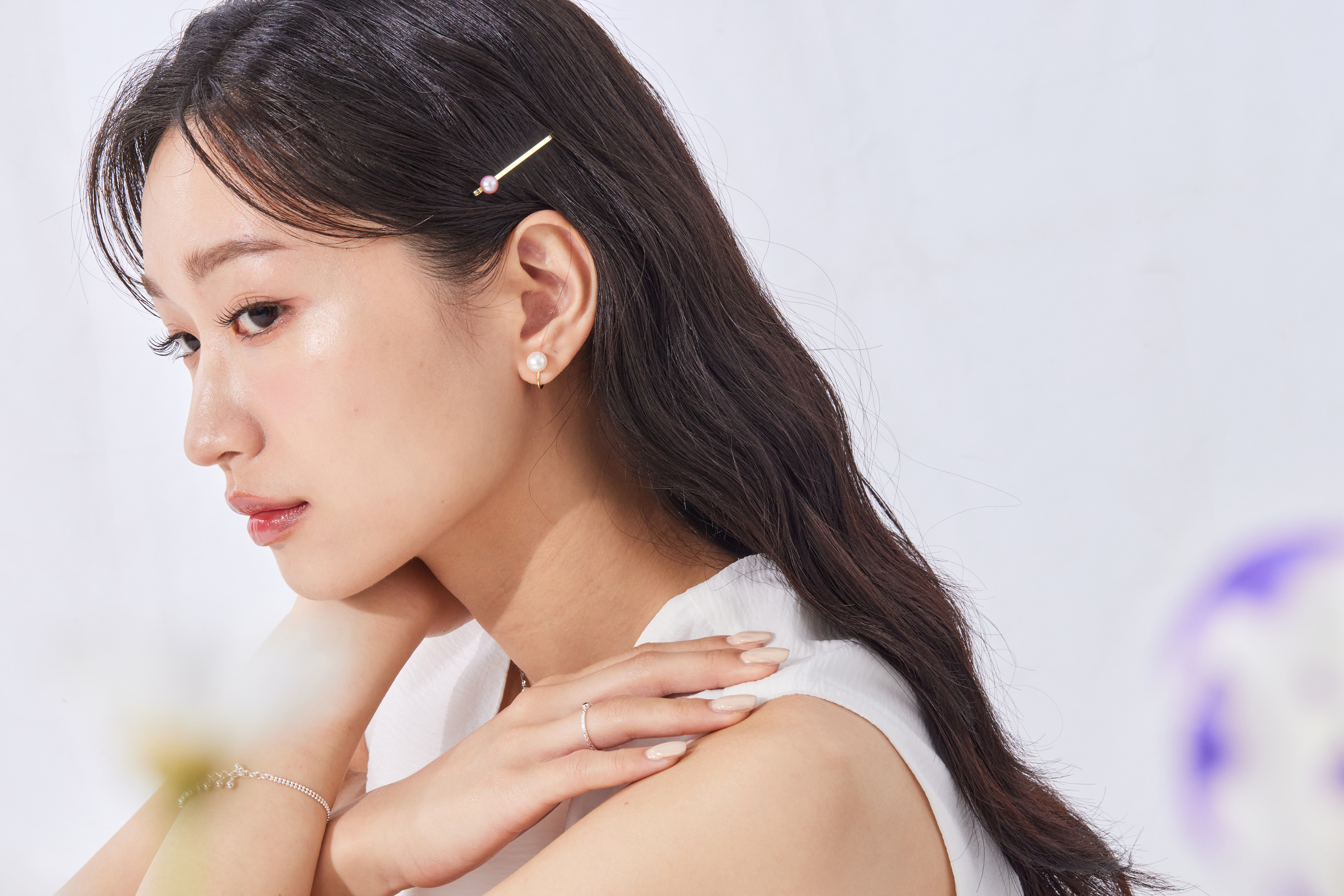 模特低頭姿態展示，珍珠髮夾自然地固定髮束