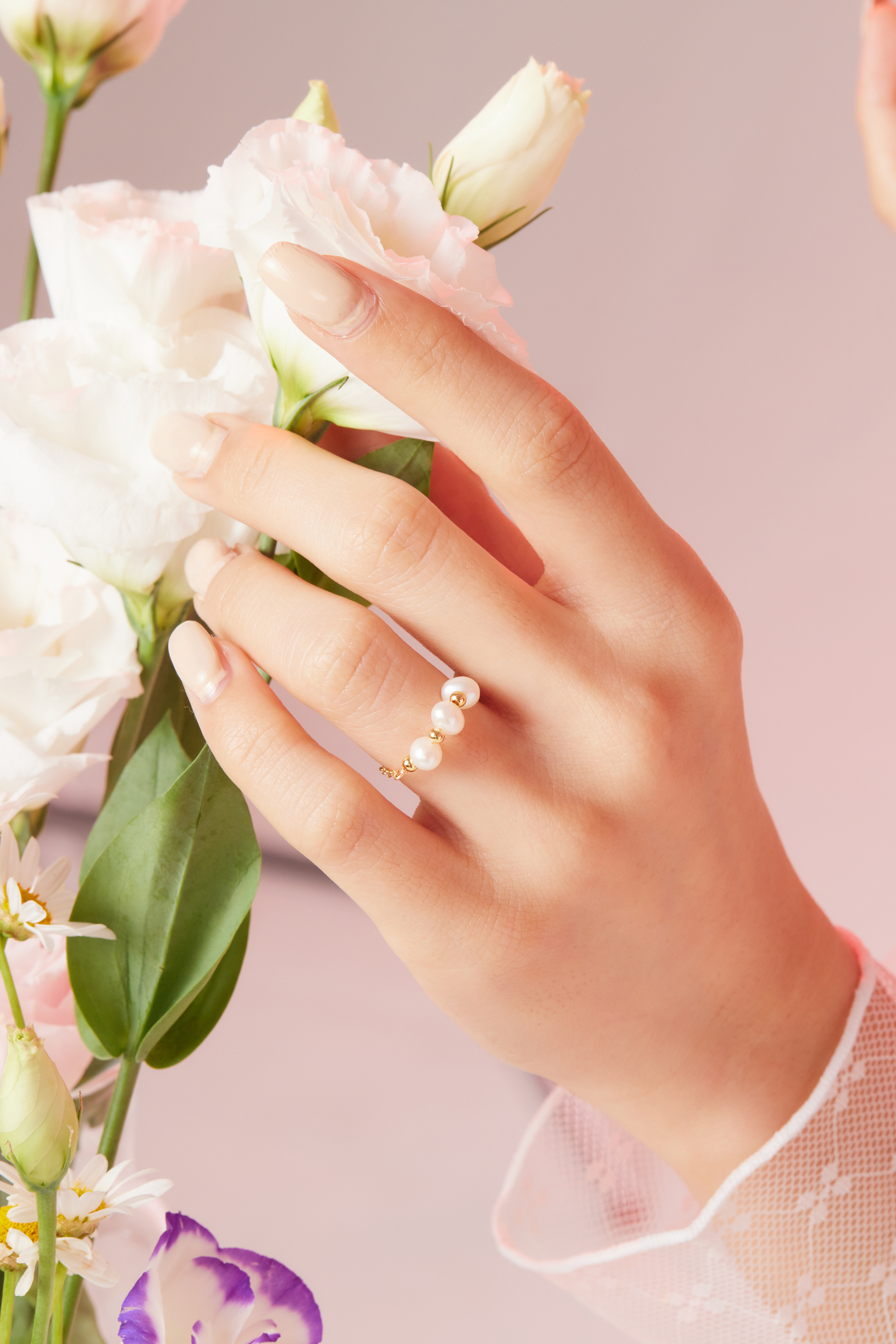 模特手部近拍，細節呈現珍珠線戒與手鍊質感。