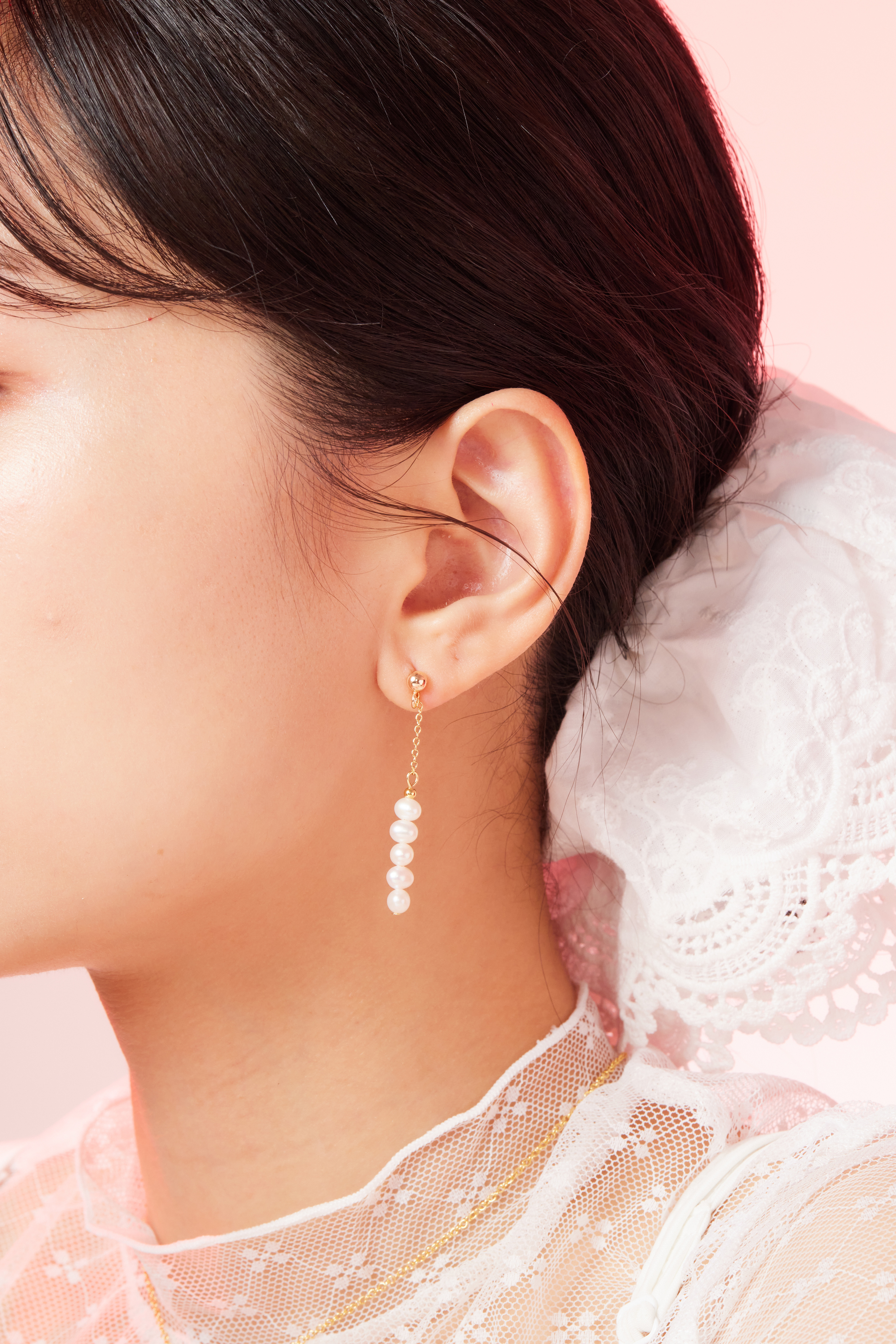 模特耳下珍珠耳環特寫，呈現自然垂墜光澤。