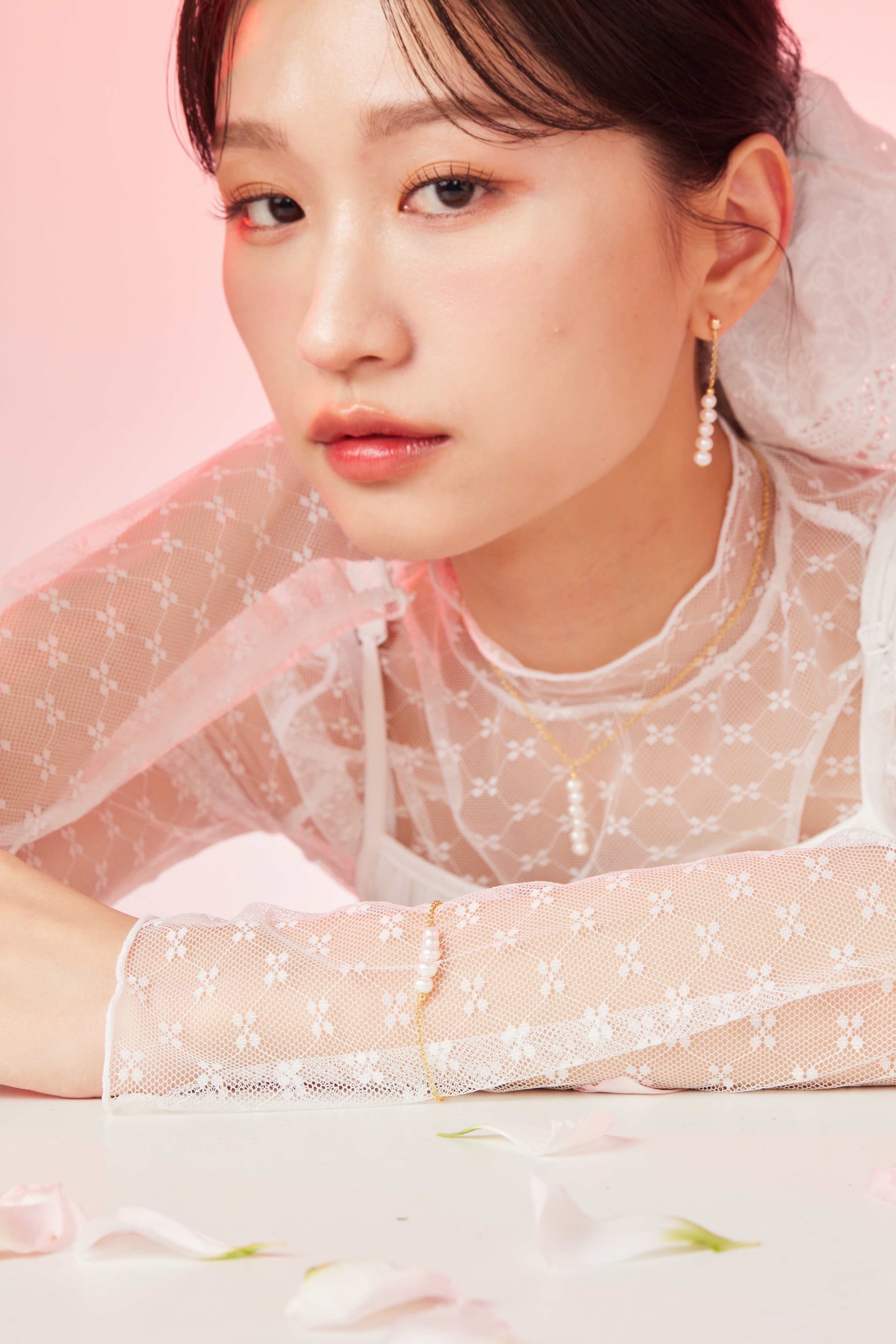 模特佩戴耳環與項鍊的中景照，搭配簡約服裝。