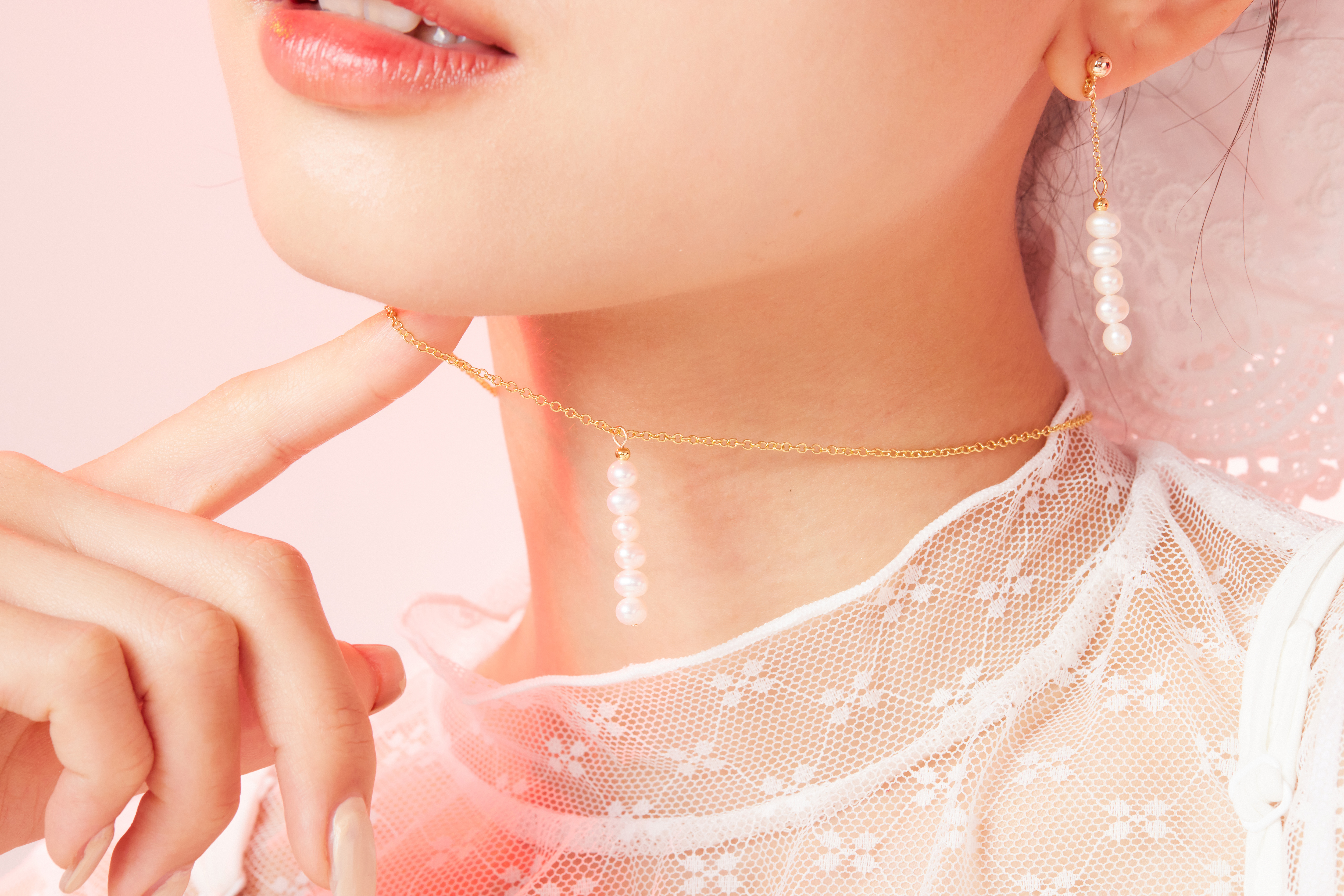 模特脖子局部近拍，項鍊珍珠細節清晰可見。