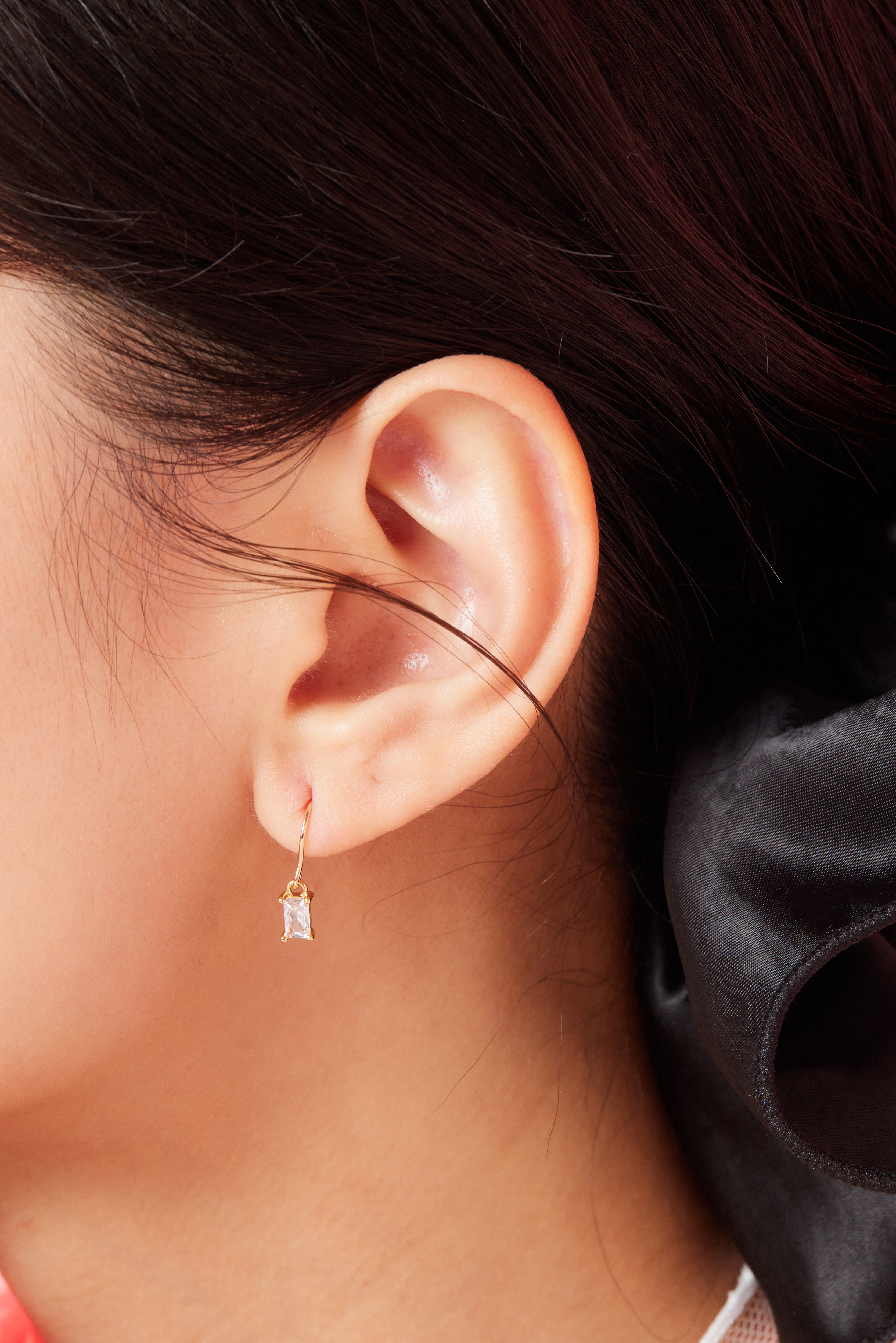 模特耳朵特寫，聚焦方形鋯石耳環的光澤感。