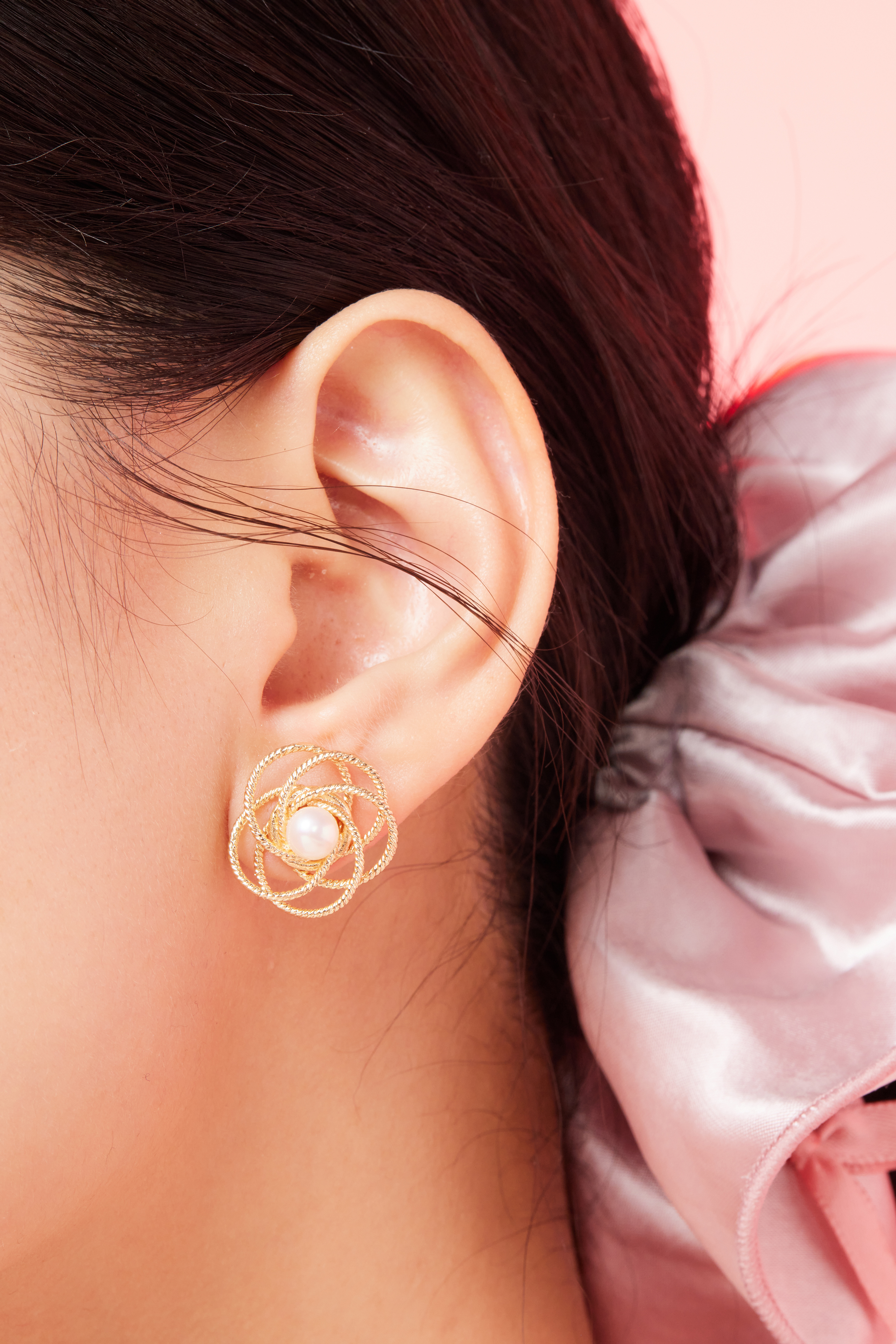 模特耳朵近拍照，清楚呈現珍珠與花朵細節。