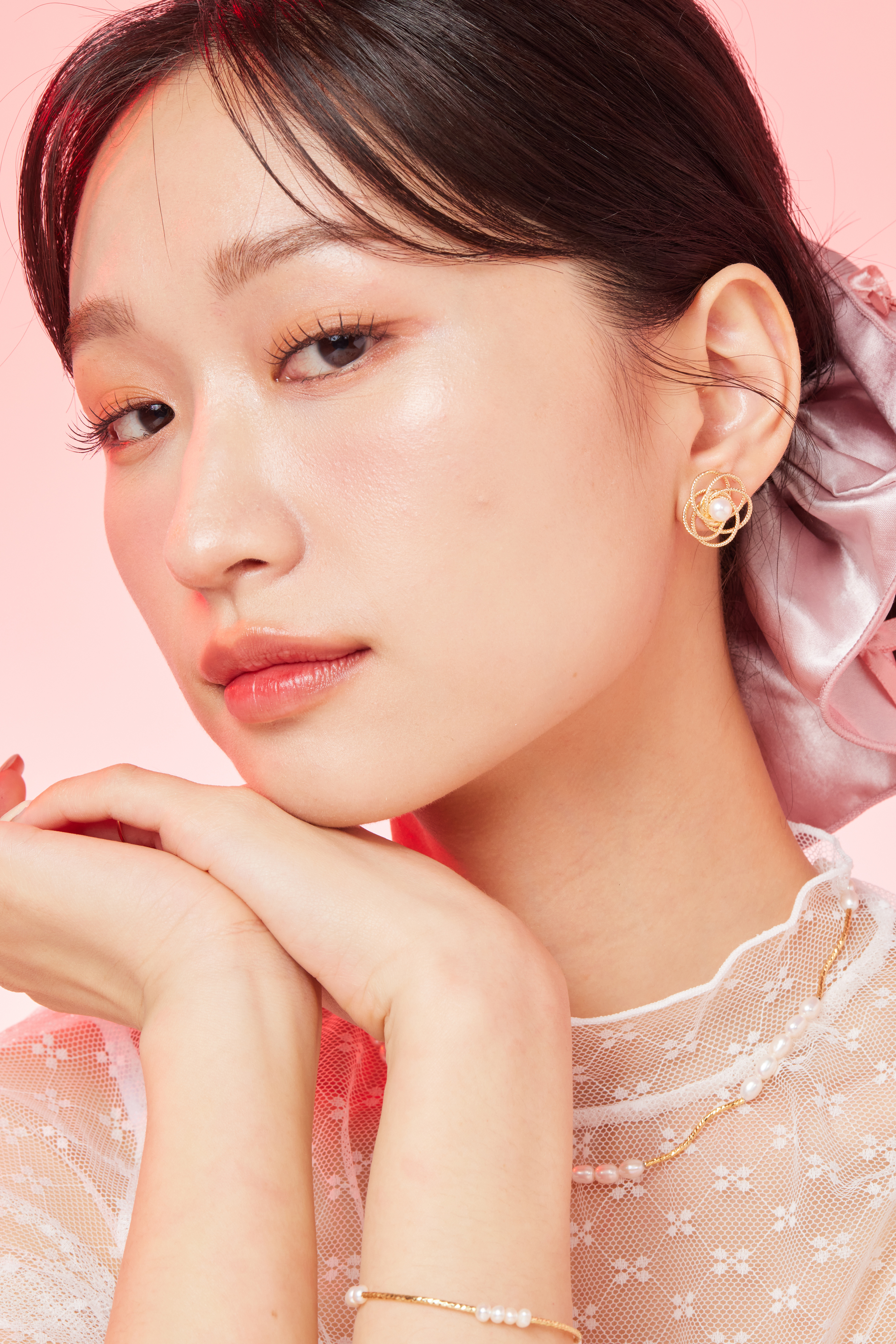 模特看向鏡頭托下巴展現耳環的精緻光澤。