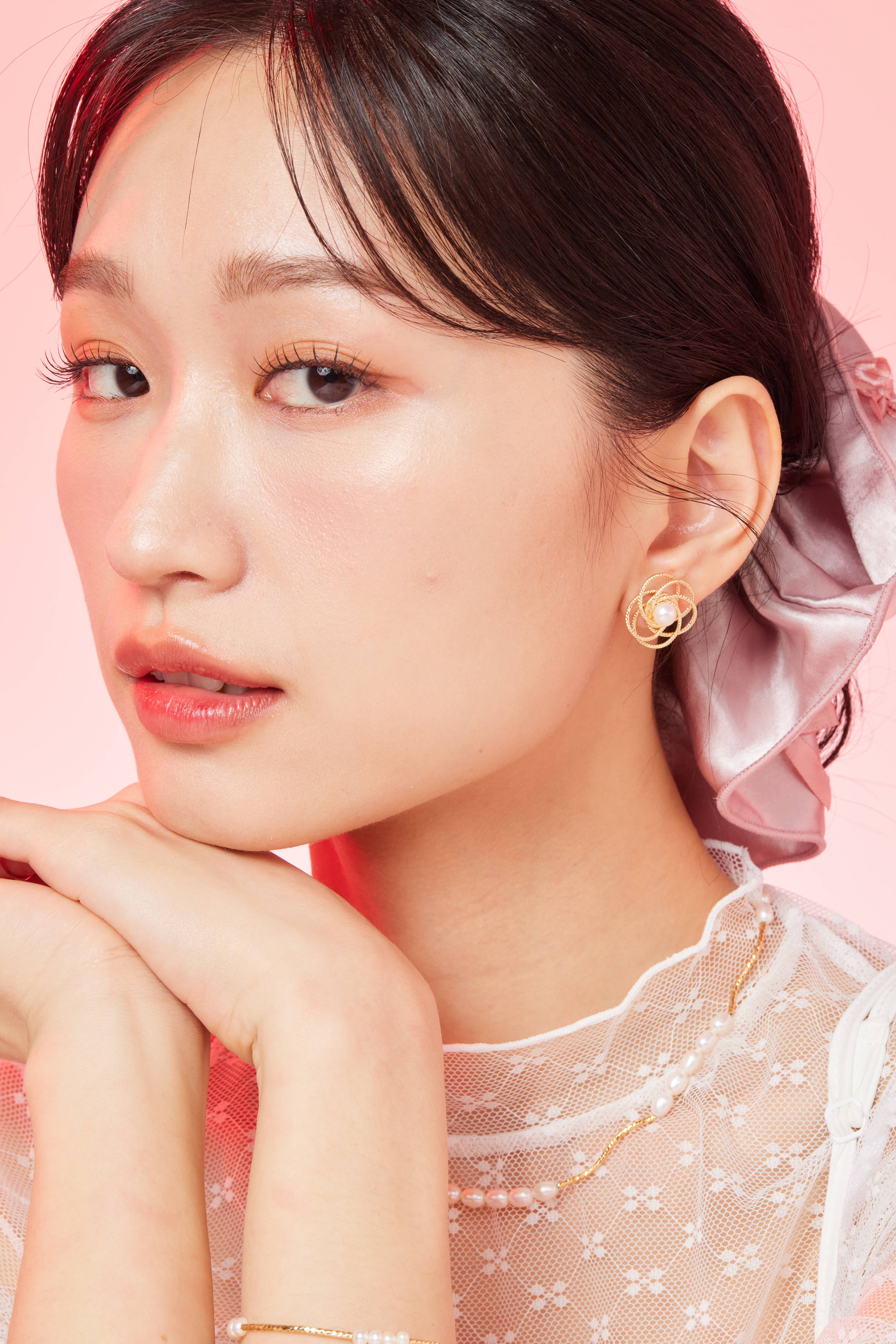 模特托下巴露出小花耳環近拍照。