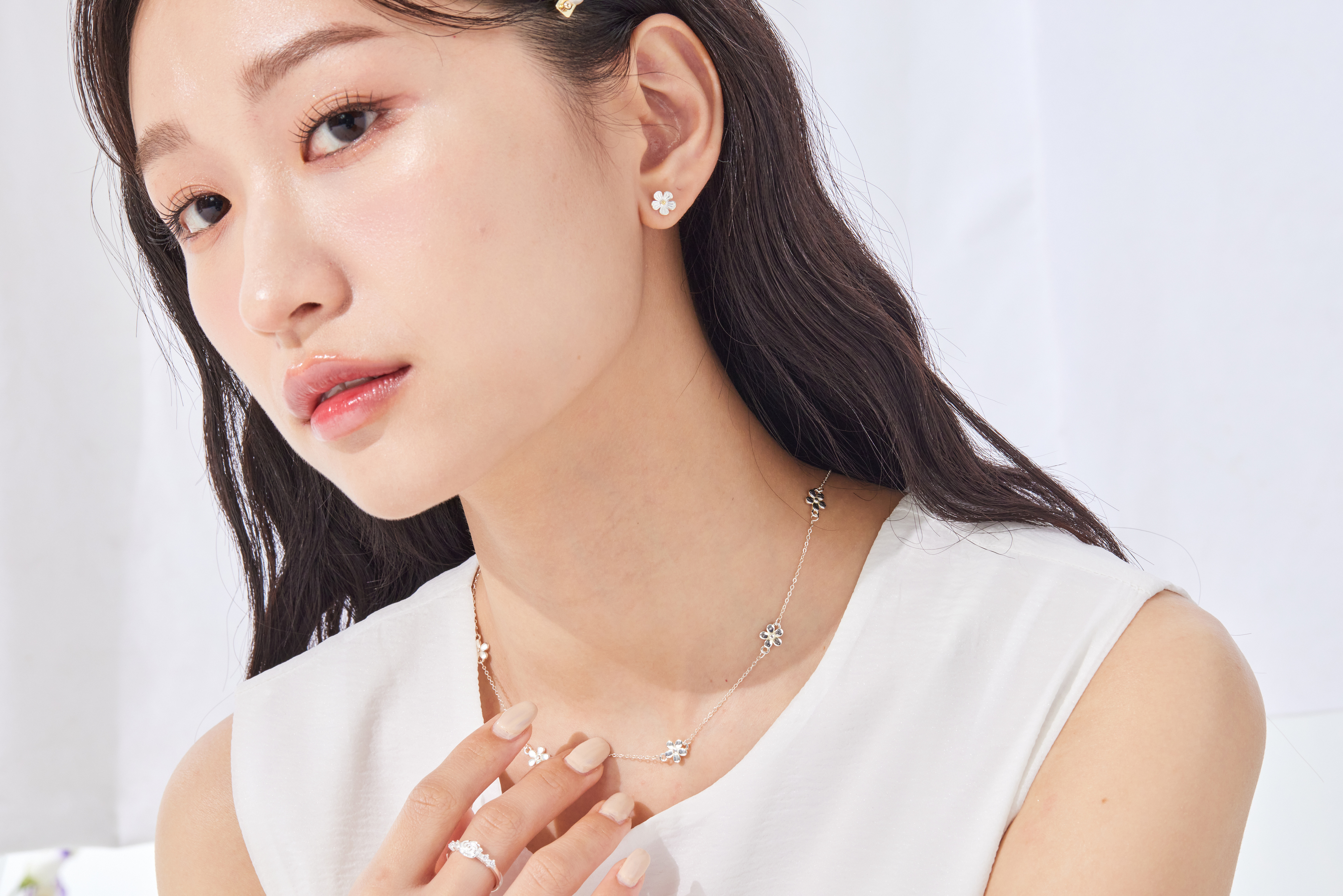 模特搭配圓領上衣，項鍊若隱若現，為簡約造型增添細節亮點。