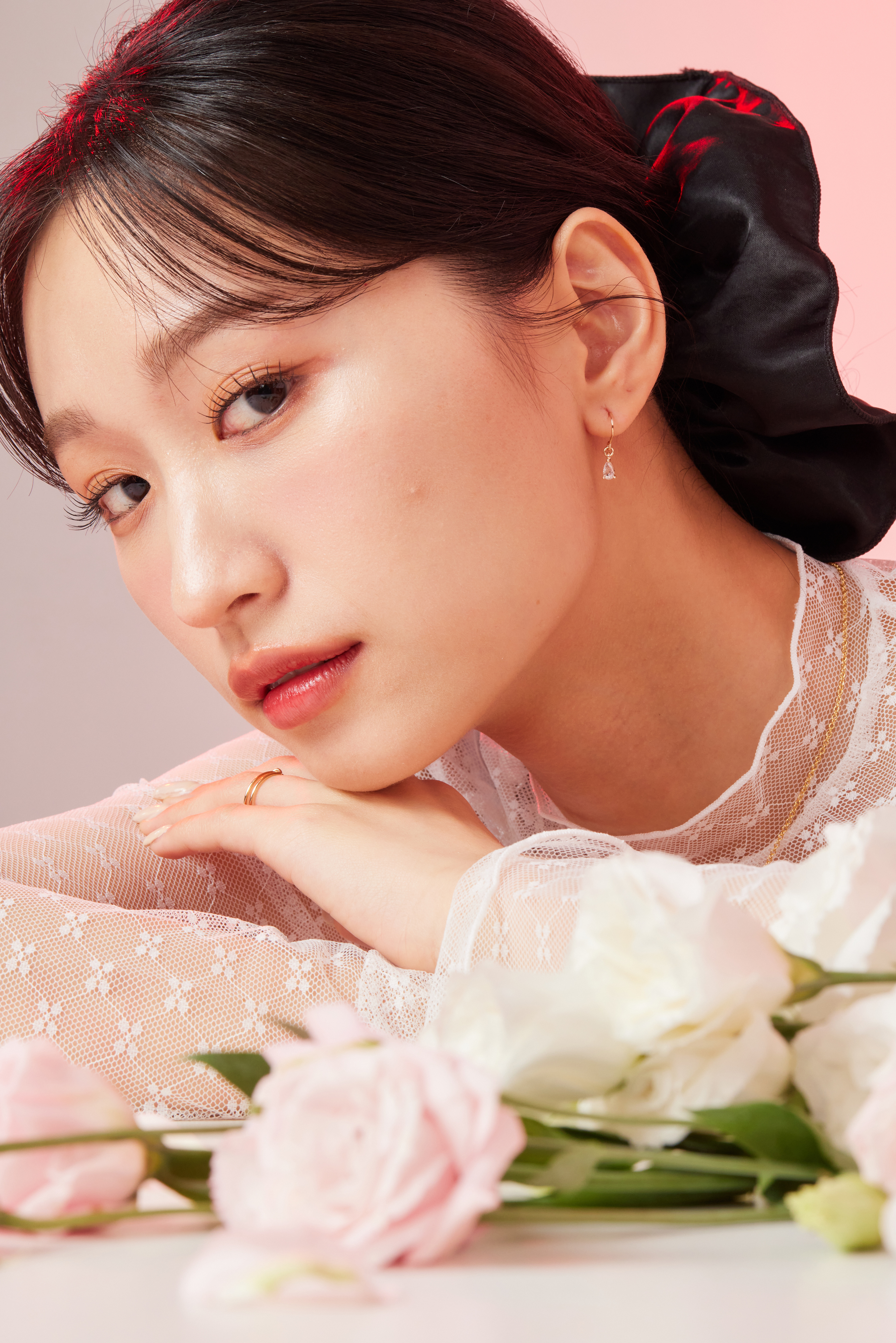 模特身穿雷斯上衣，耳環在整體造型中低調點綴，散發優雅質感。