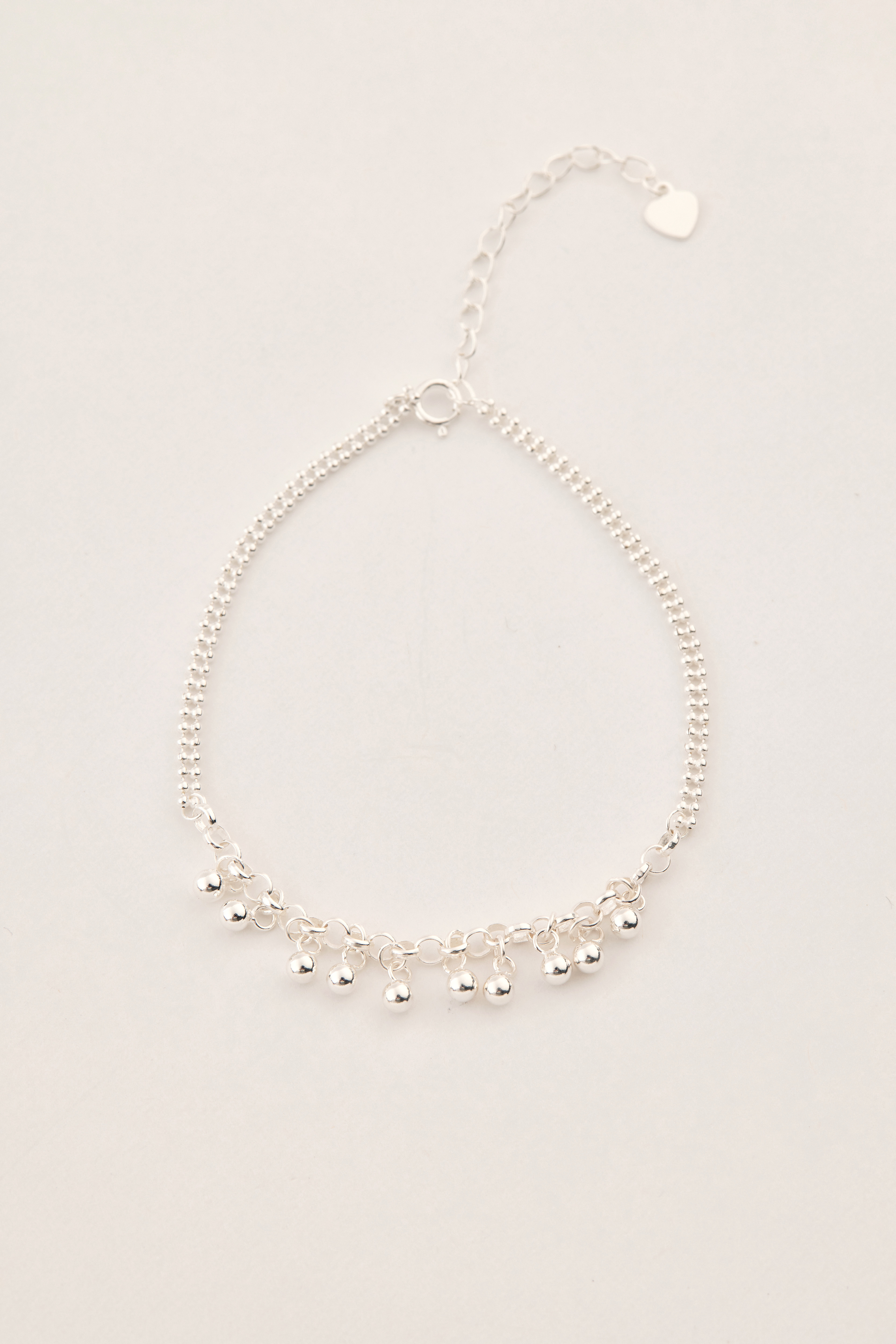 手鍊平放於桌面上，銀珠自然垂墜，鍊身線條流暢，展現輕盈感。