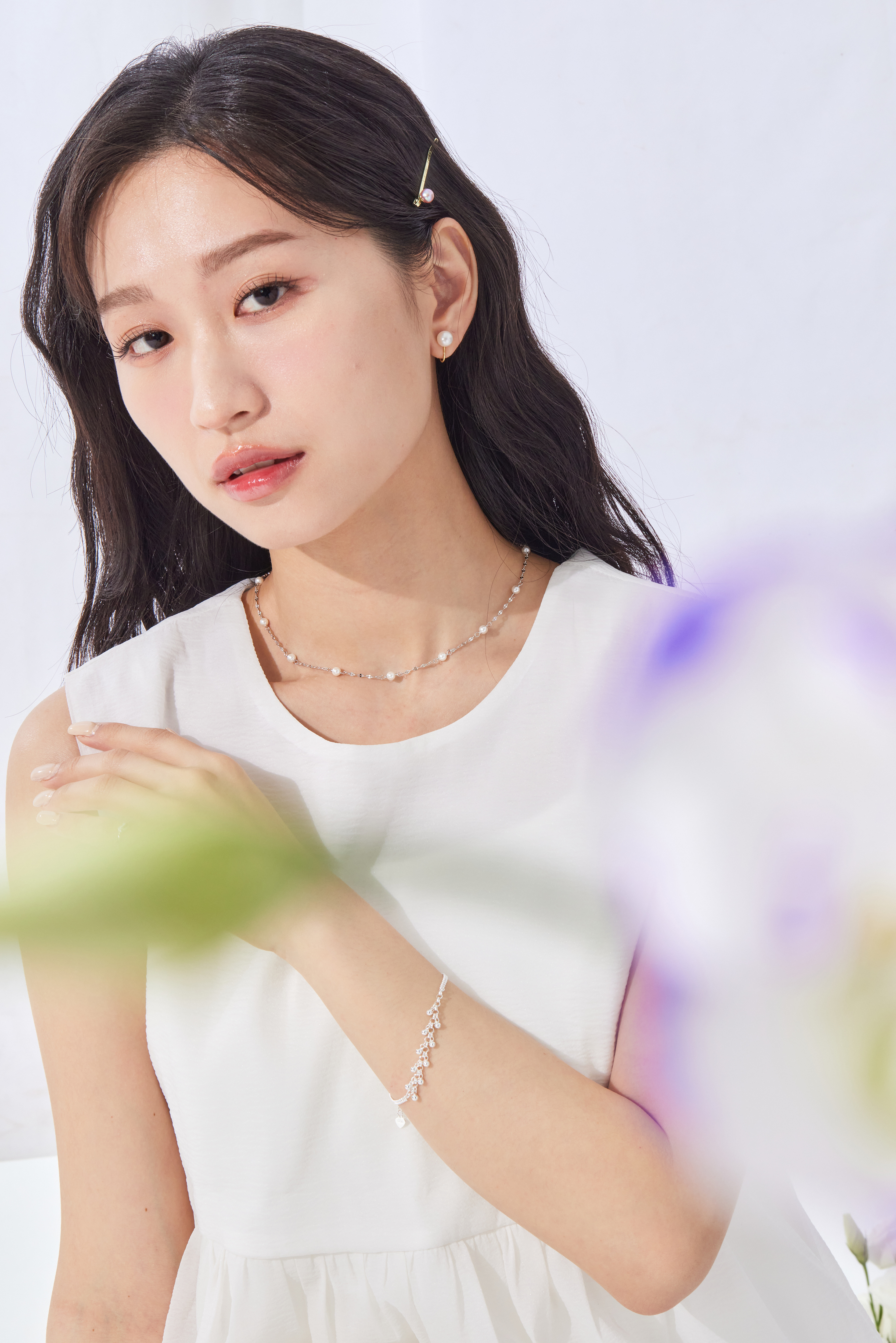 模特穿著素色上衣，銀珠手鍊作為亮點配飾，增添穿搭層次。