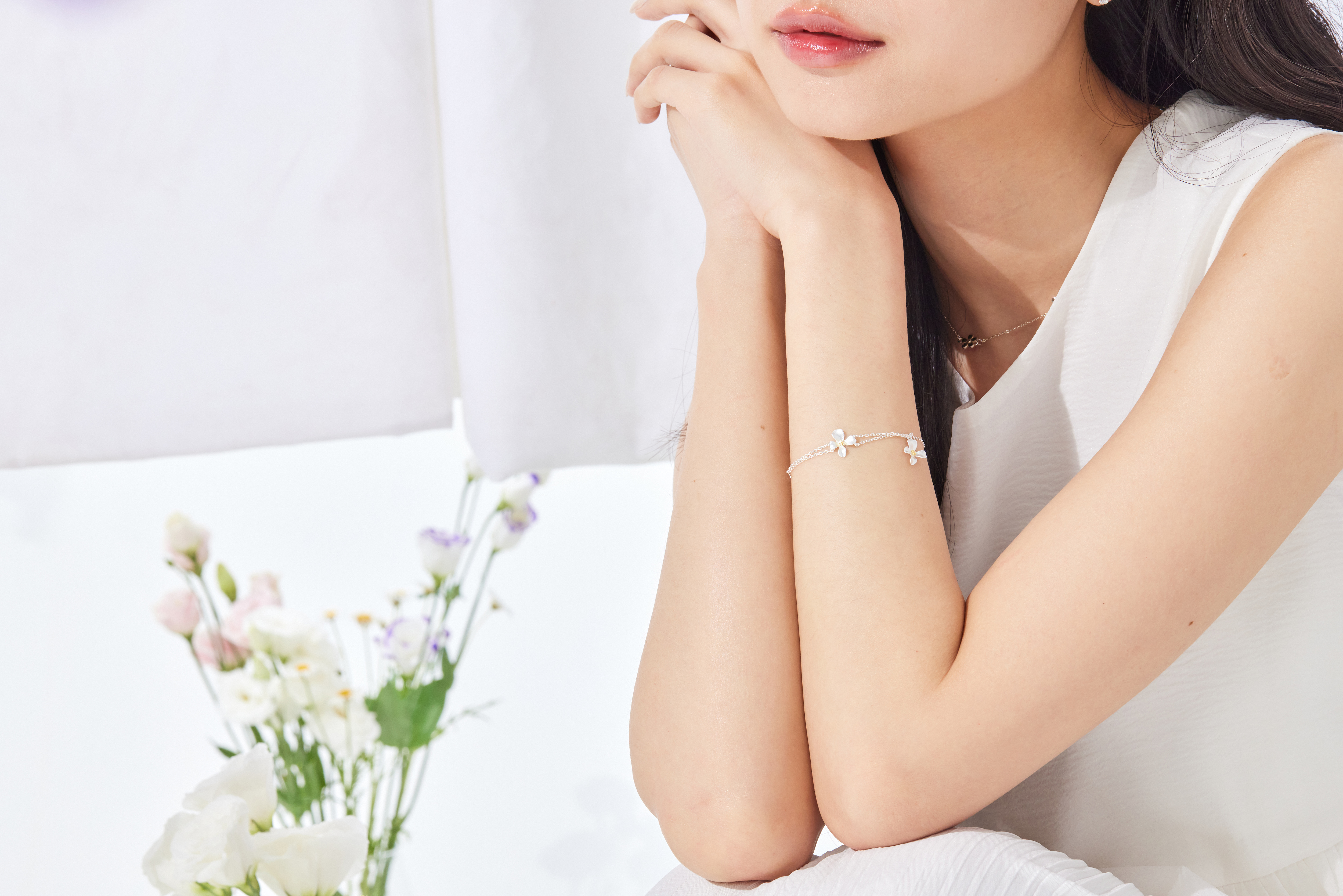 模特側拍手部，雛菊墜飾細節清晰，點綴肌膚展現優雅溫柔感。