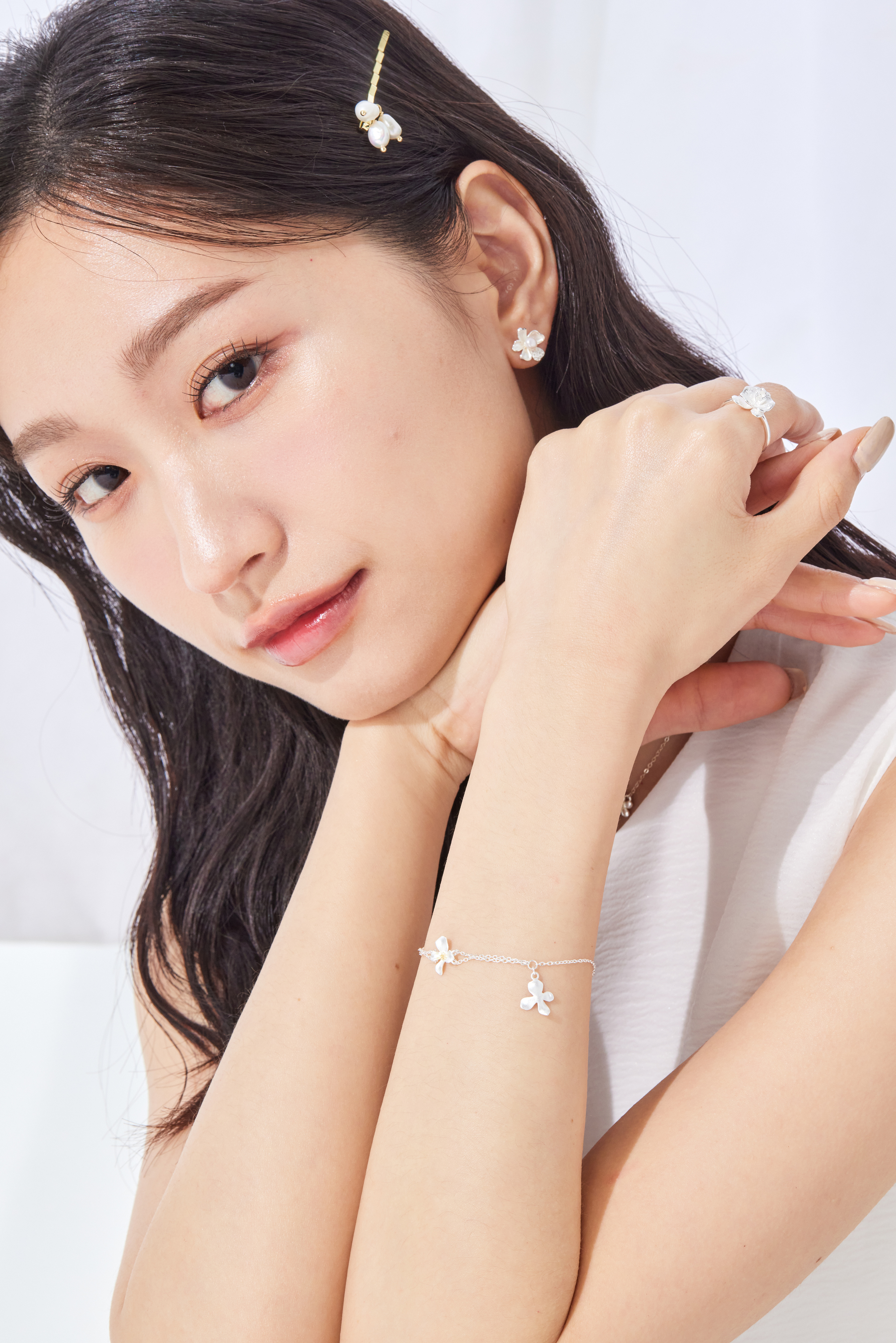模特與白色背景合拍，純銀小花手鍊映出溫柔光芒，清新氣息滿溢。