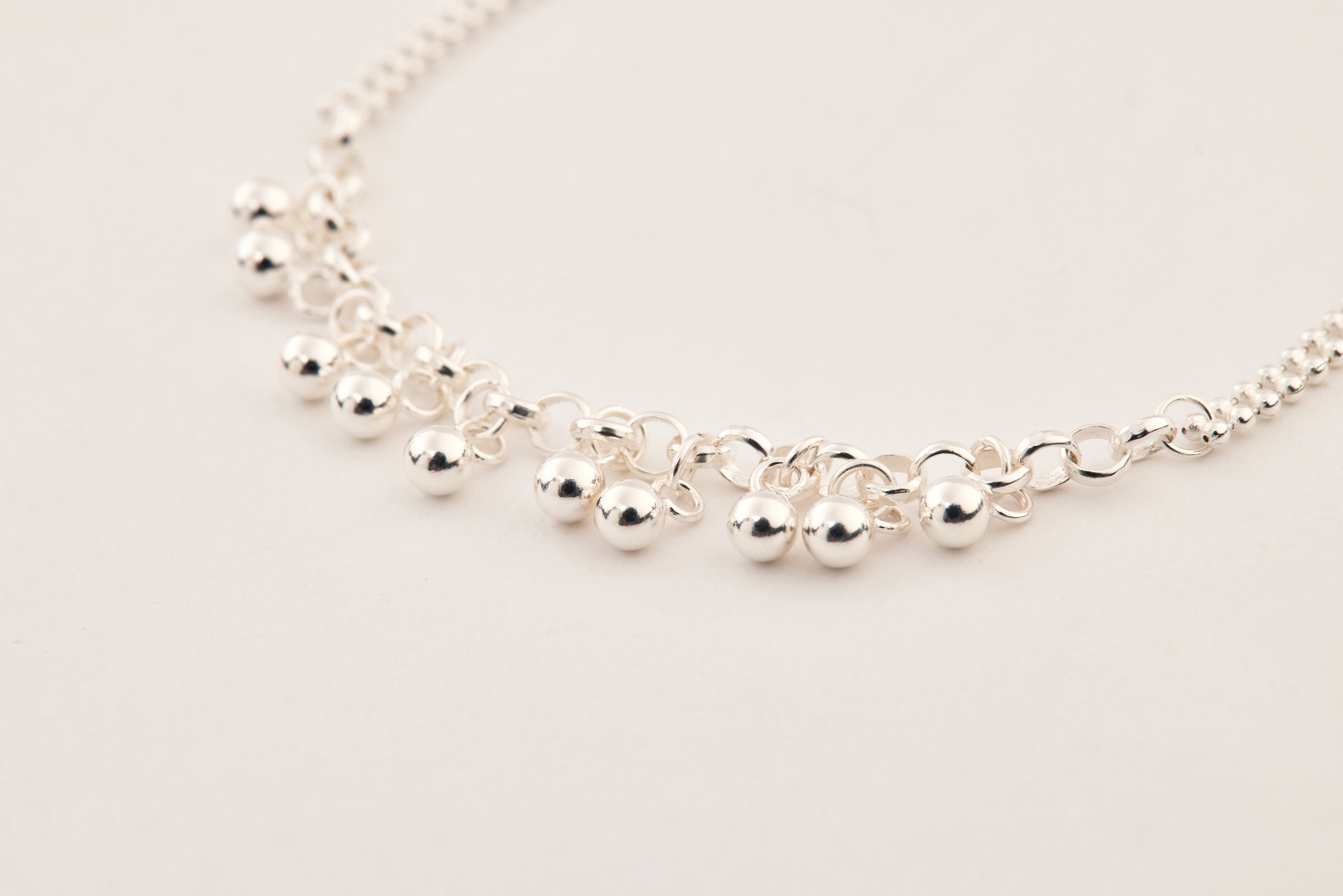 銀珠細節特寫，表面圓潤鏡面拋光，每一顆珠子皆反射光影，精緻質感一覽無遺。