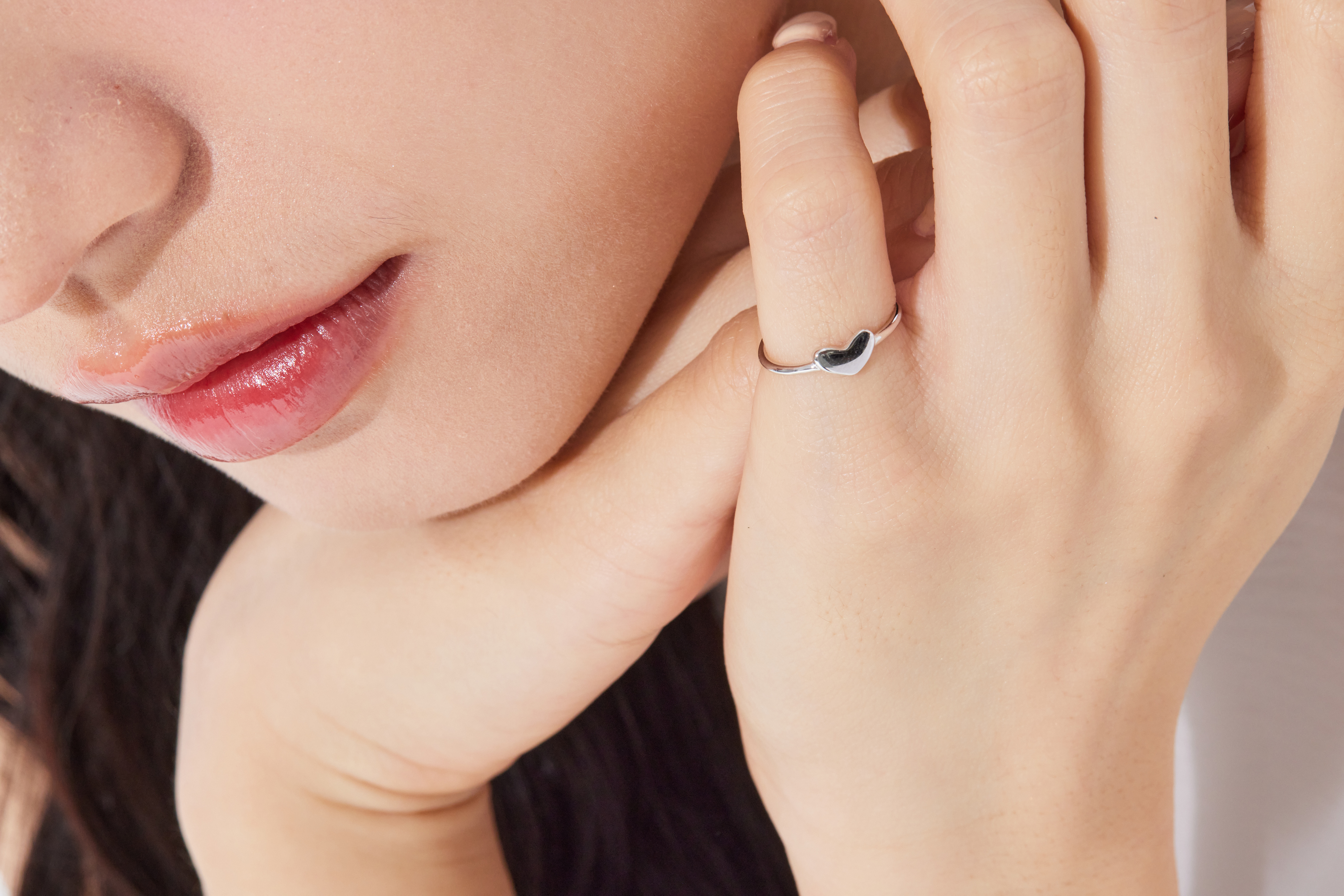 模特手指特寫，愛心尾戒戴於小指上，小巧設計與肌膚貼合，精緻感十足。