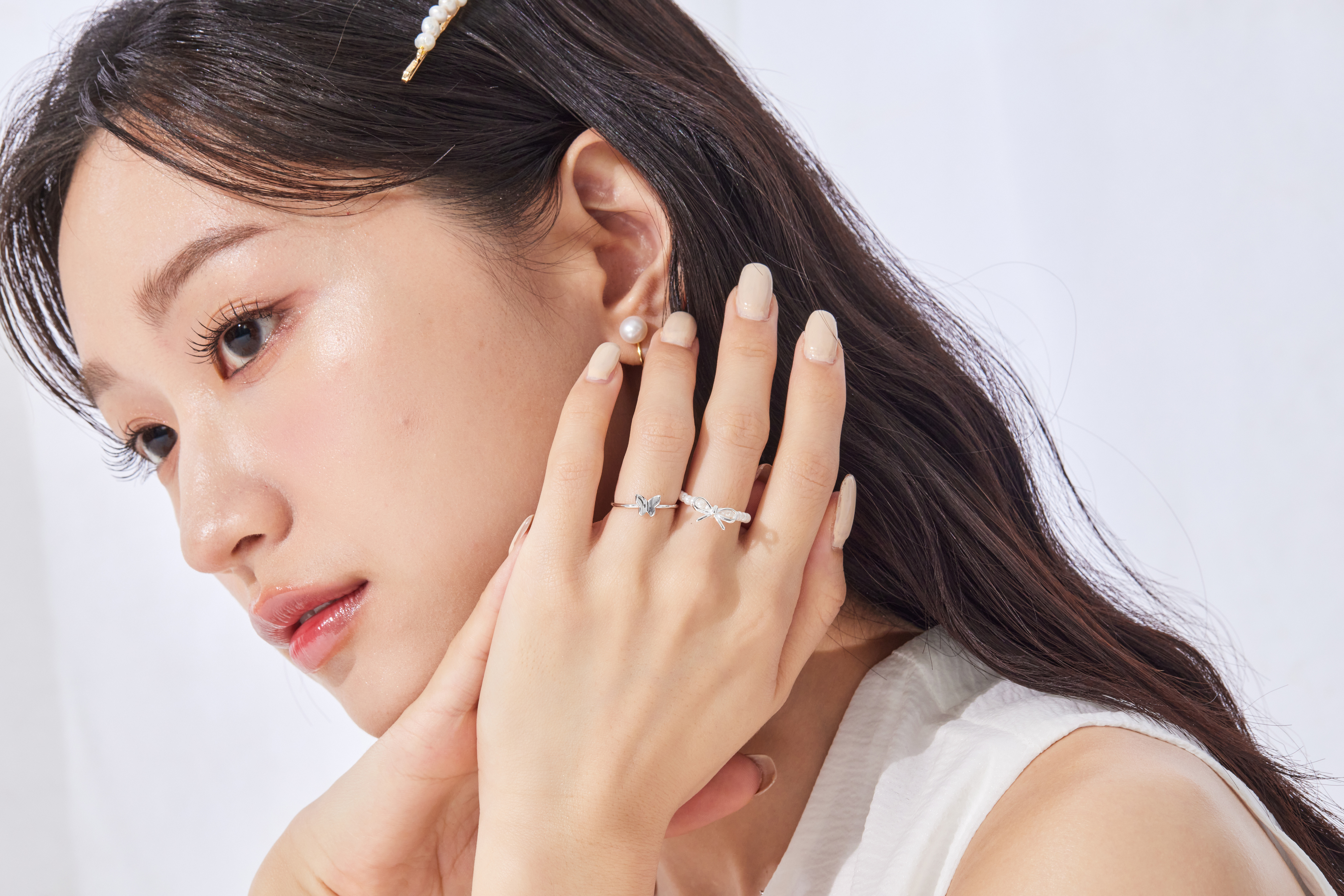 模特正拍手部，蝴蝶造型清晰可見，純銀質感襯托出柔美氣息。