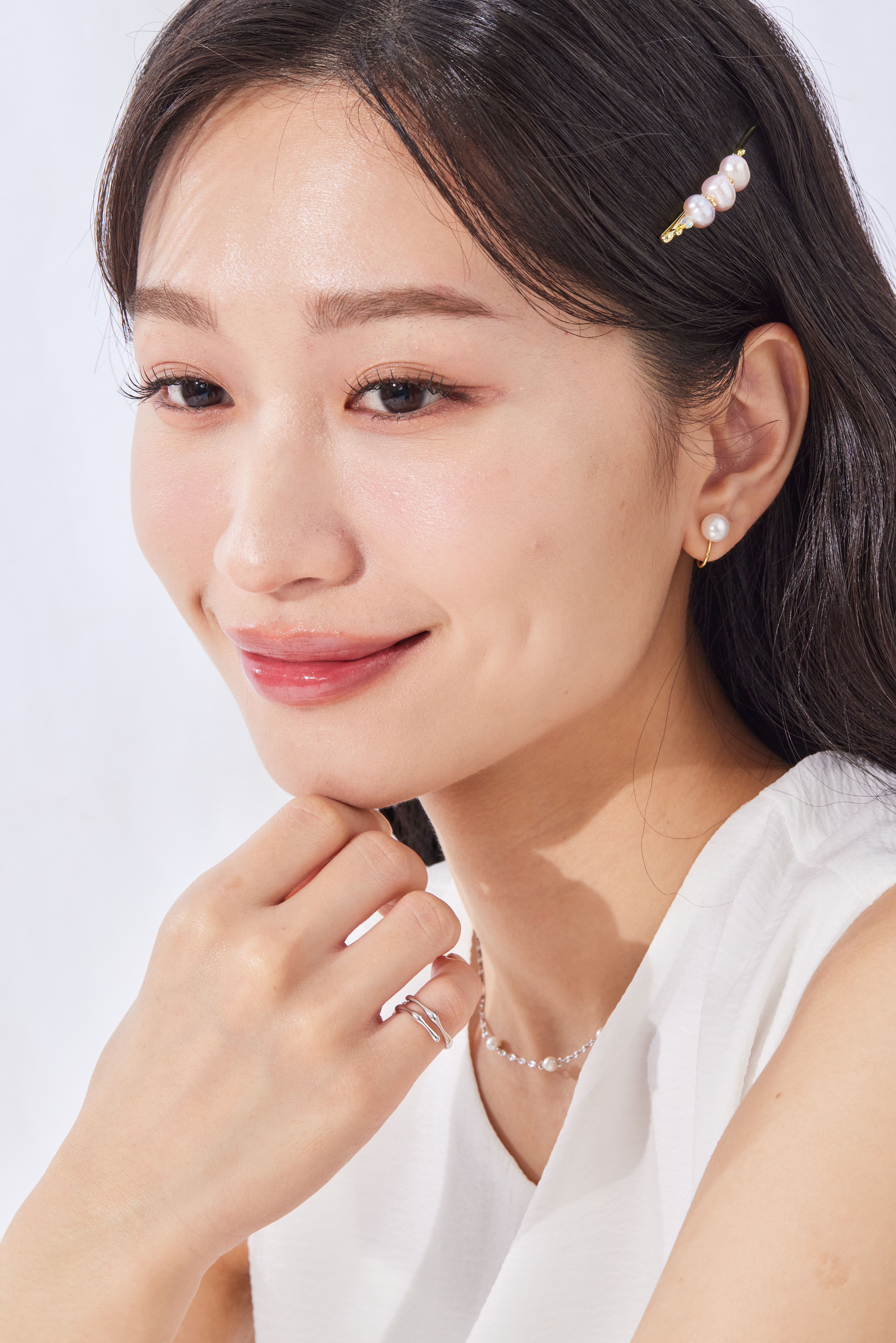 模特輕摸下巴，戒指於小指靜靜閃耀，細節中藏著設計巧思。