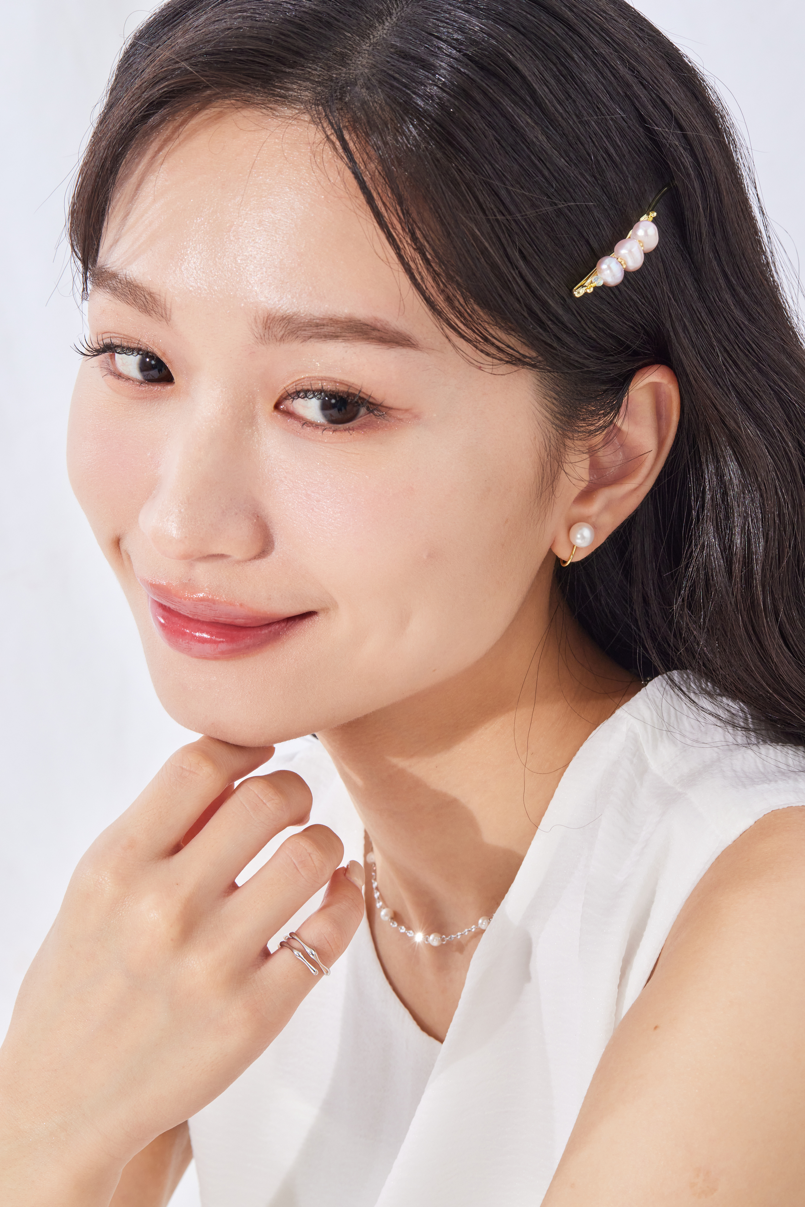 模特手部微舉，流線戒指搭配素色上衣，散發質感極簡風。