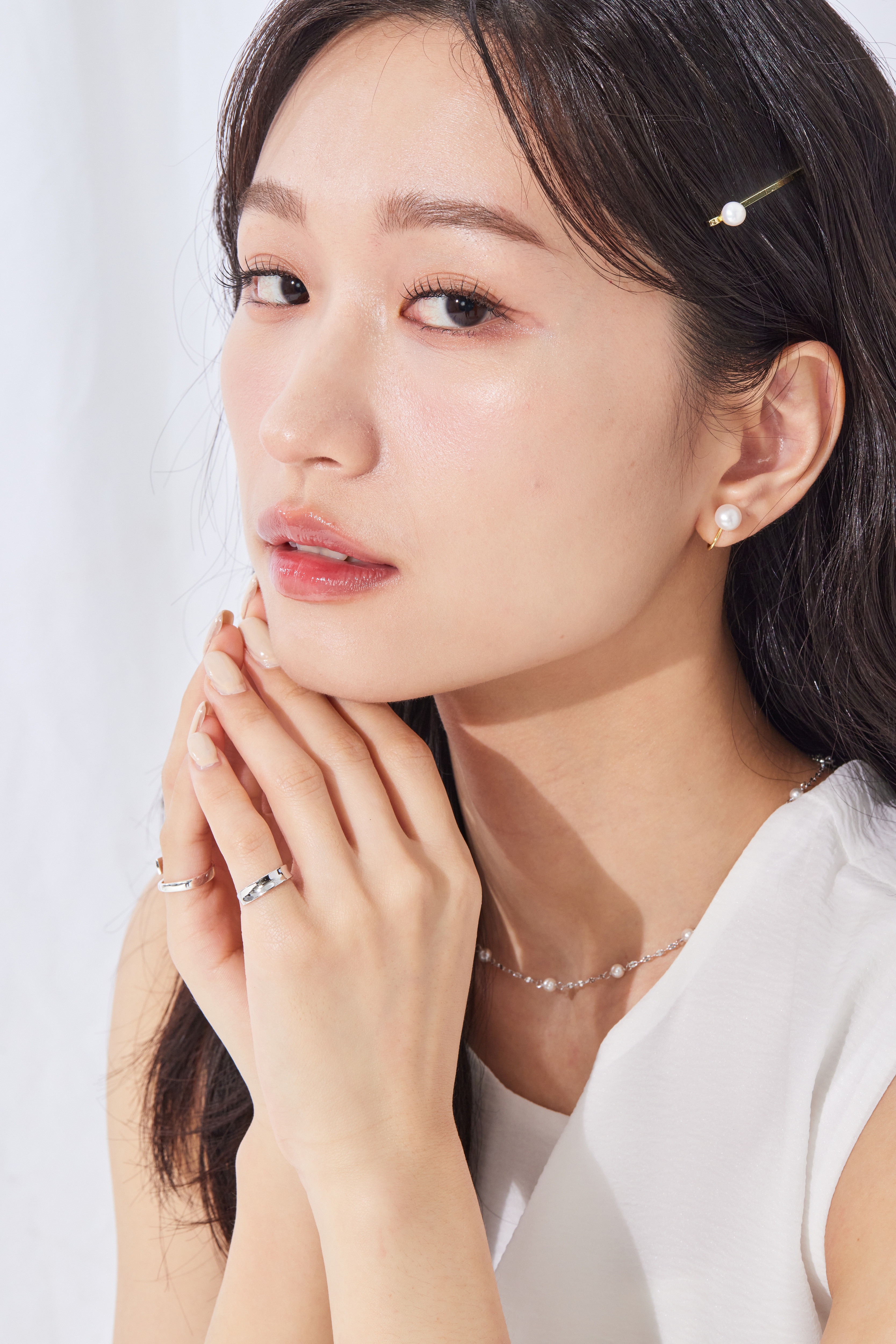 模特穿著極簡白上衣，搭配不同戒指，開口尾戒成為俐落亮點。