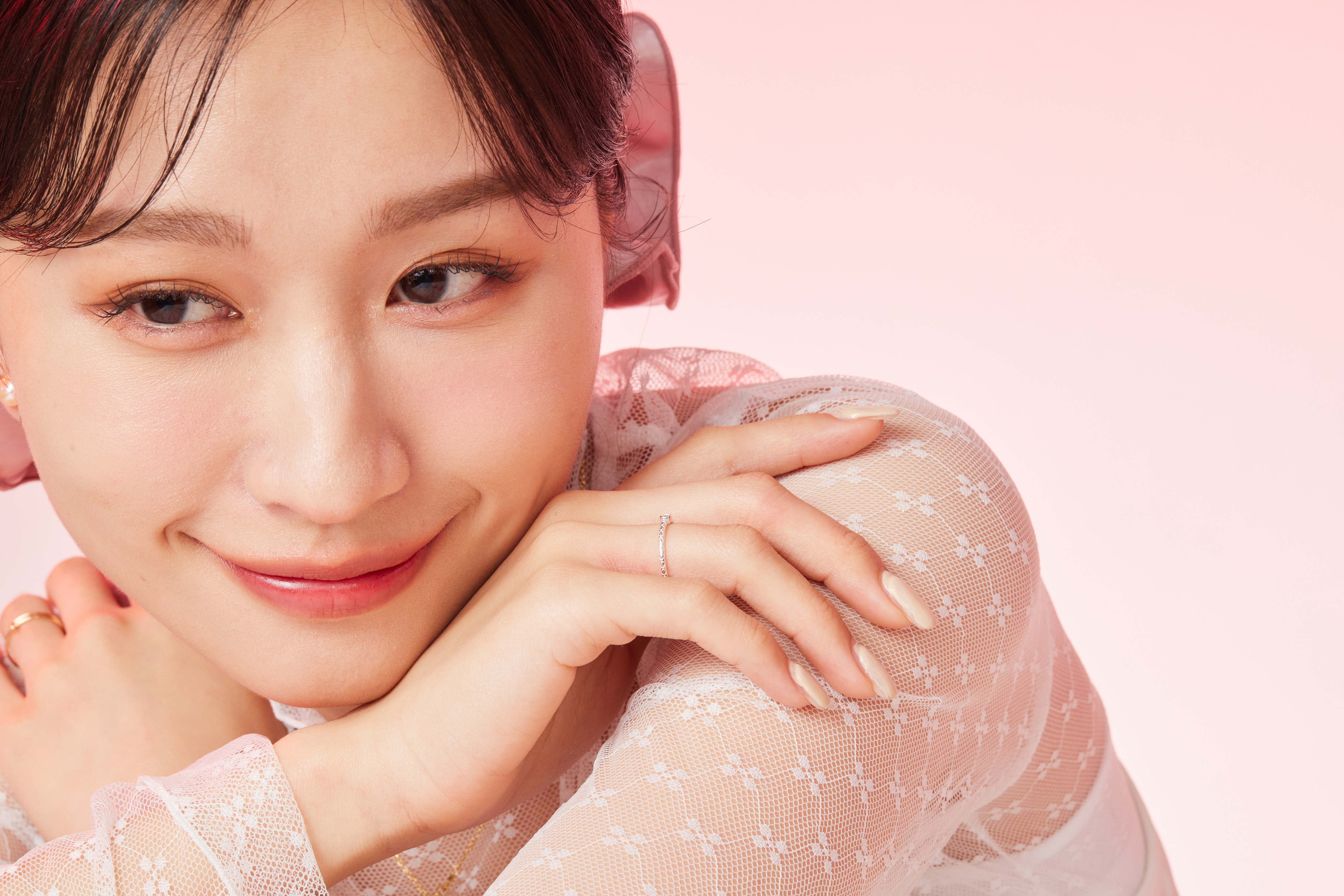 模特甜美靠在手上，粉色鋯石展現出柔美的風格。