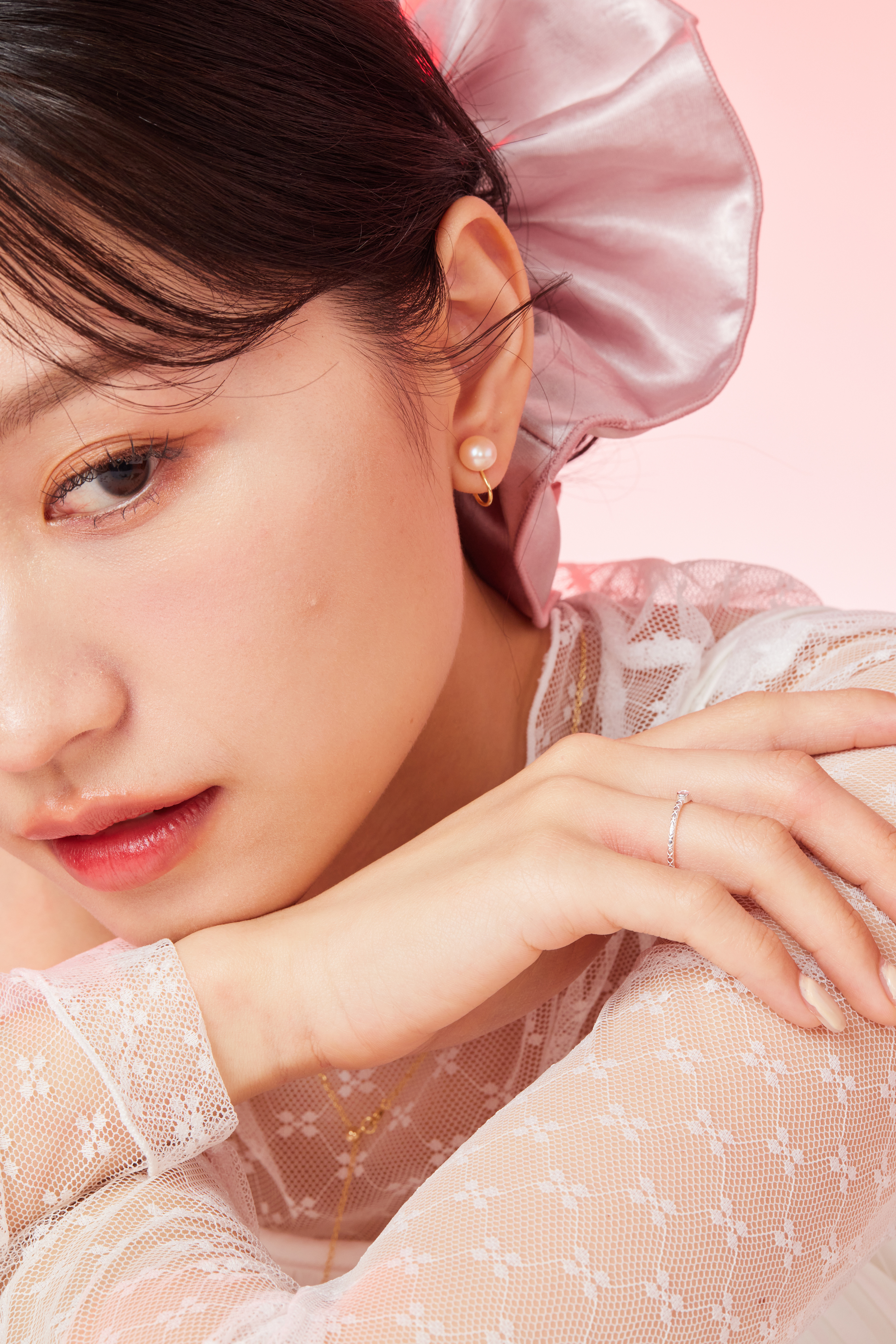 模特靠在手上，粉色鋯石戒指於指間閃爍，氣質清新柔美。