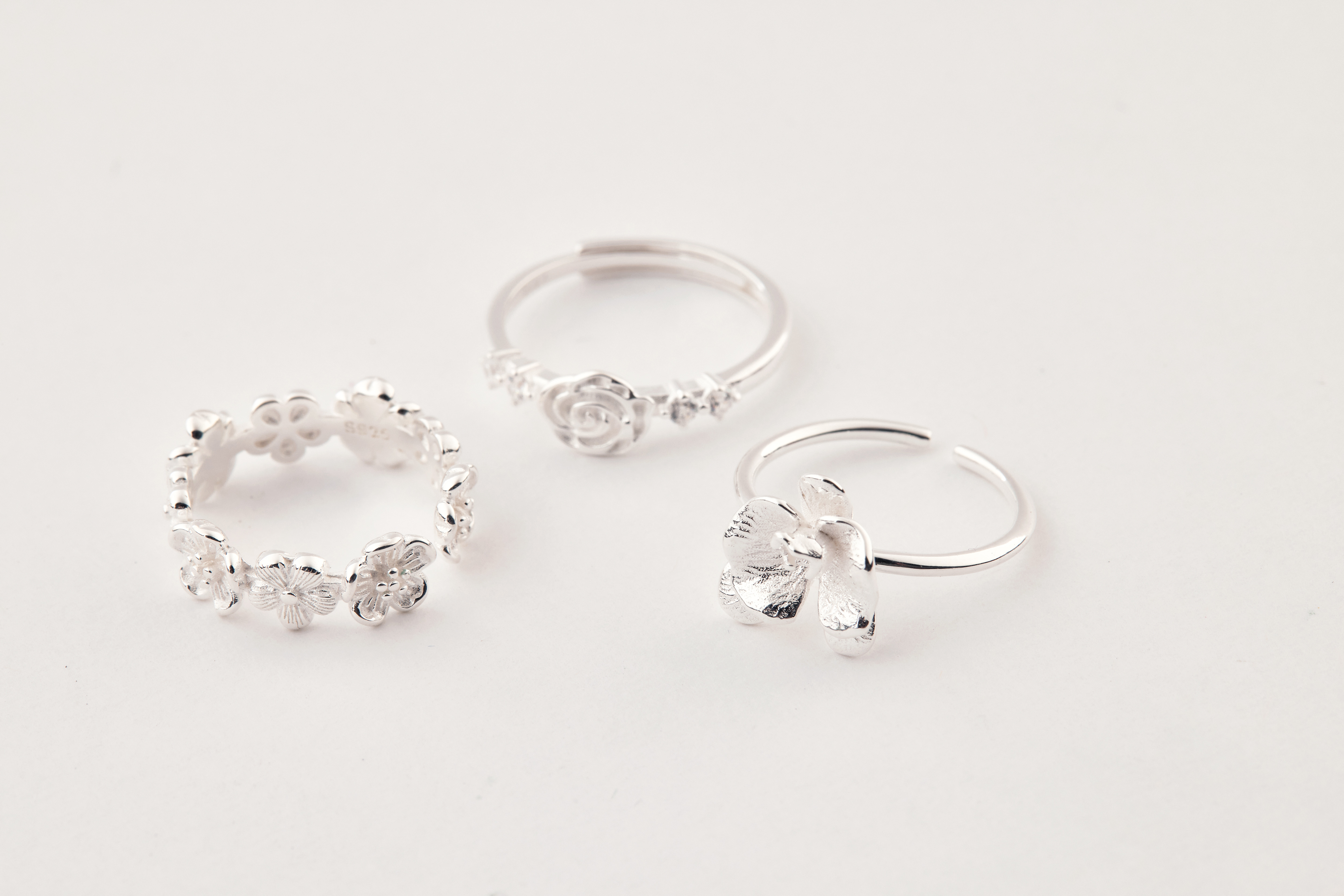 小花戒指與另外兩款純銀戒指並排擺放，呈現疊戴搭配靈感與多種風格選擇。