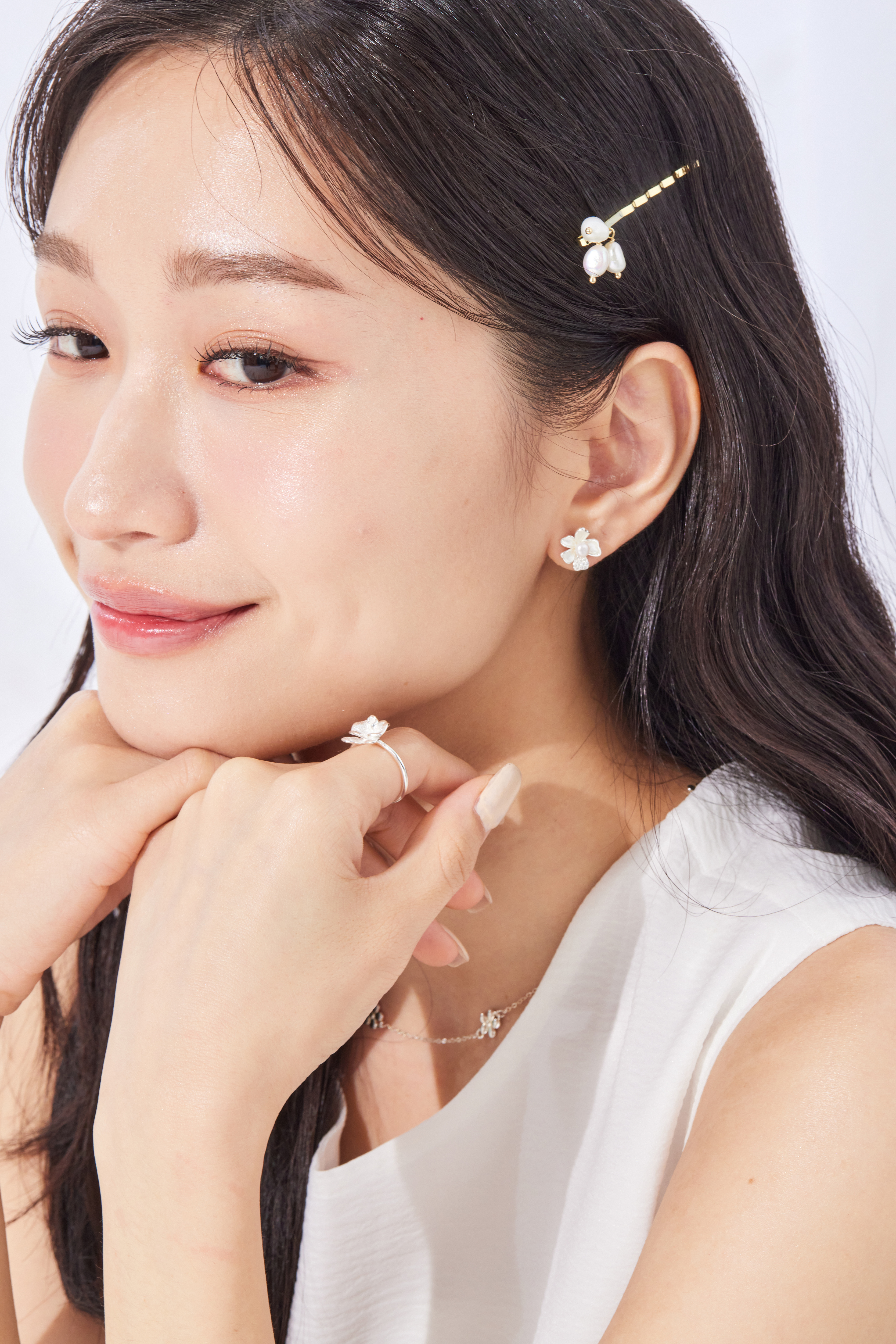 模特舉手微笑，戒指隨手勢閃耀純銀光澤，氣質溫婉。