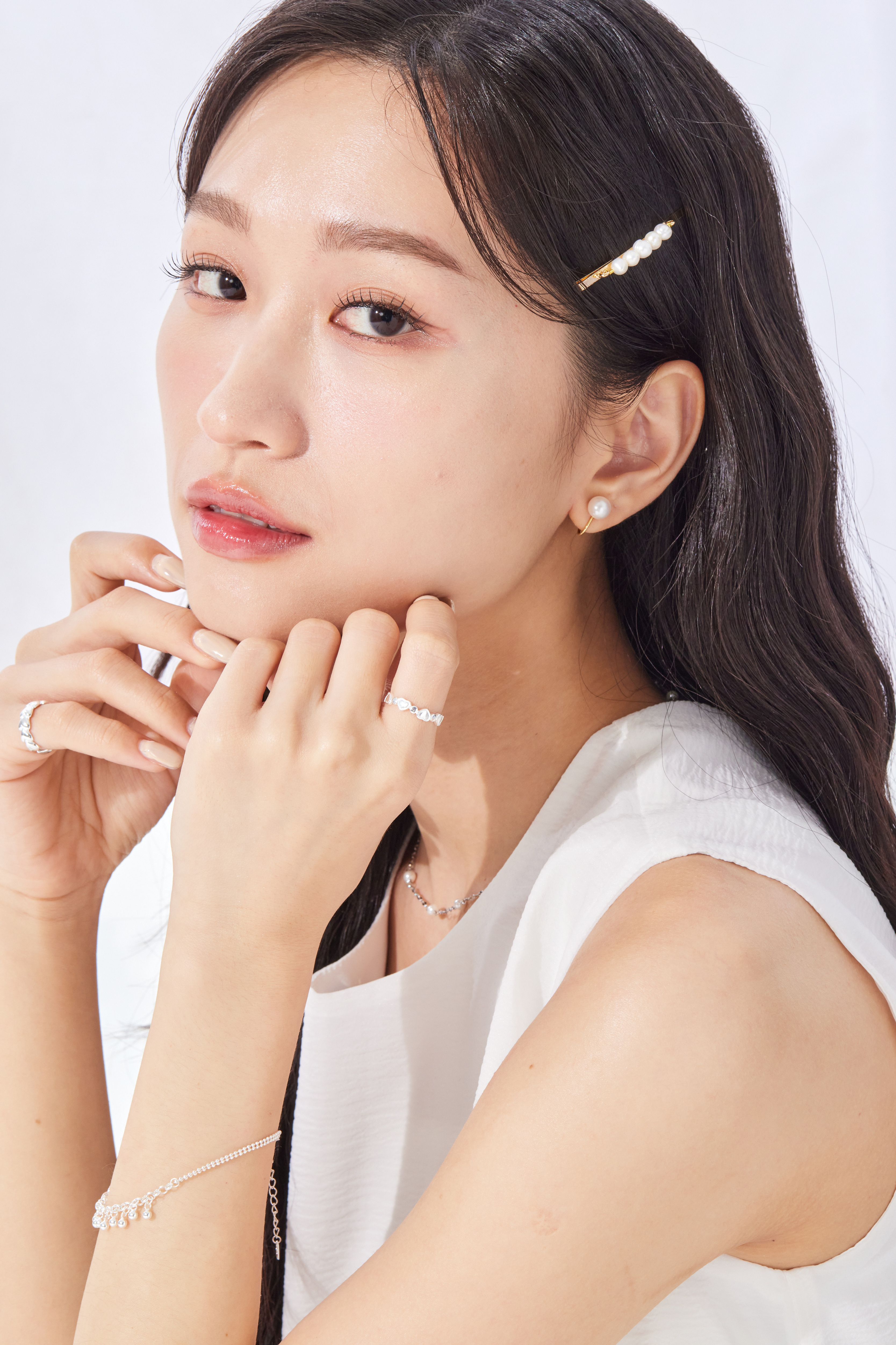 模特摸下巴，愛心戒指作為點綴飾品，增添手部柔和氣質。