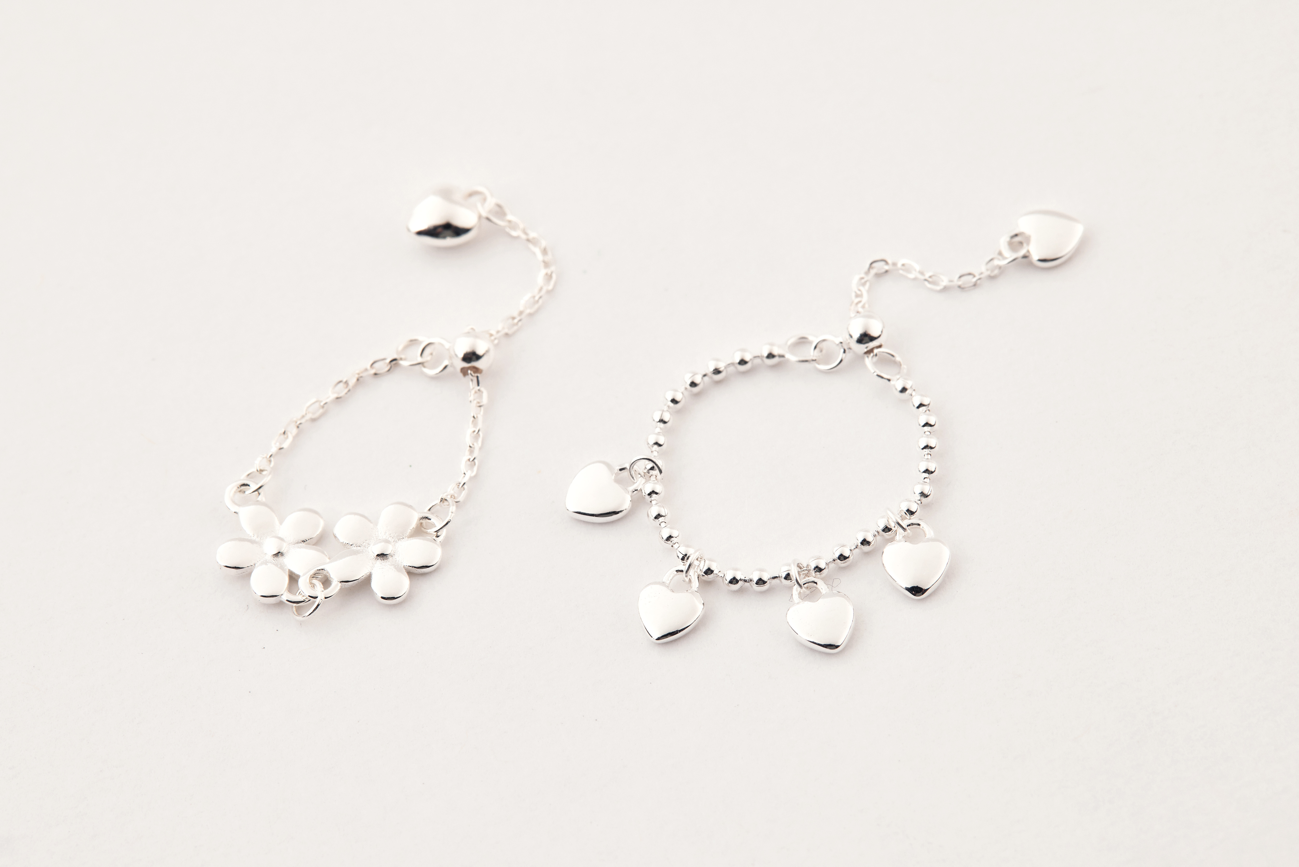 兩款戒指同框陳列，都以細緻鍊條設計形成視覺亮點。