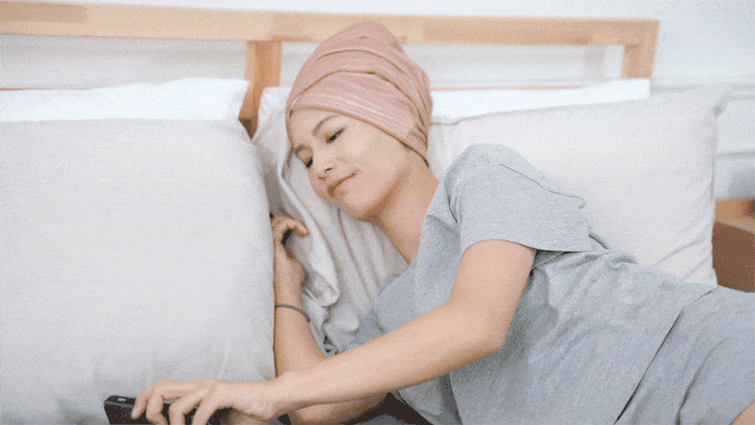 女孩包頭髮躺在床上玩手機