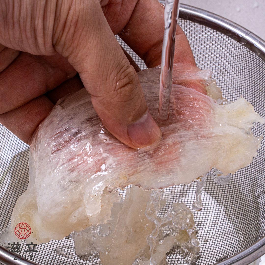 二、清洗  使用過濾的網勺將泡發好的燕窩撈起。  用清水慢慢沖洗燕窩，順著撕成條狀。  反覆沖洗幾次後，將燕窩放置在碗內。