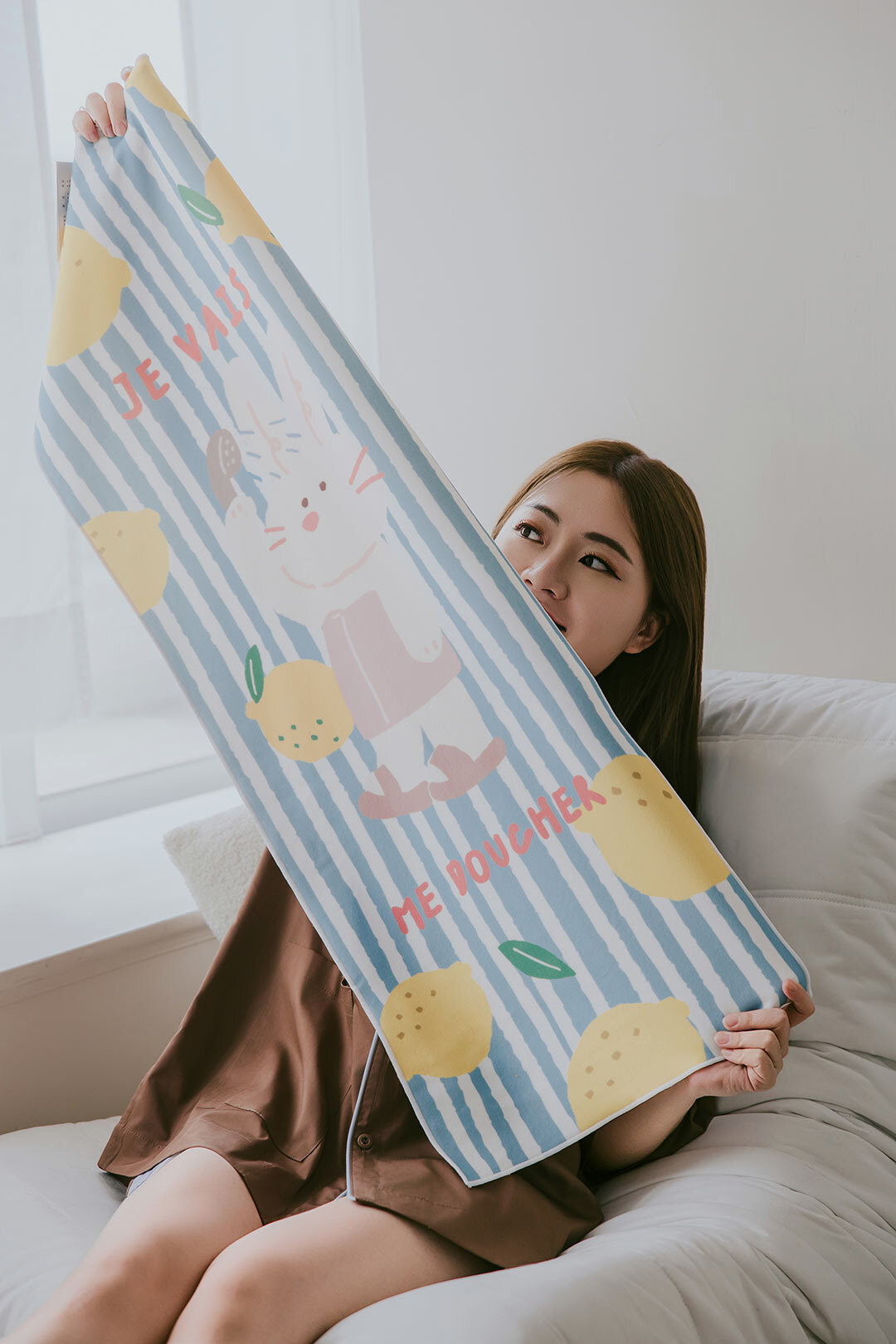 女孩坐在沙發上拿著擦髮巾