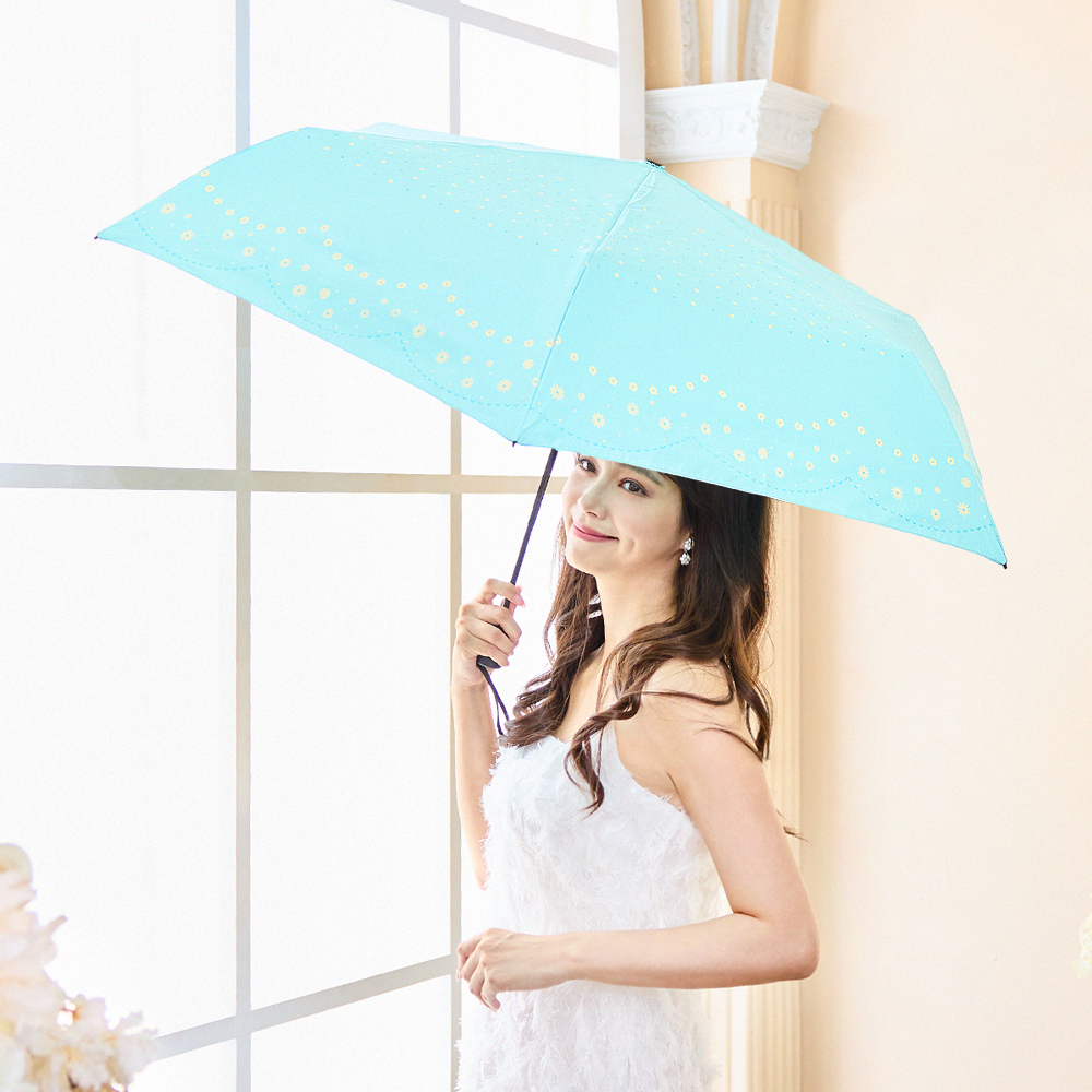 一位身穿白色連衣裙的年輕女性撐著環保紗降溫10℃自動傘水玉_水綠看向窗外