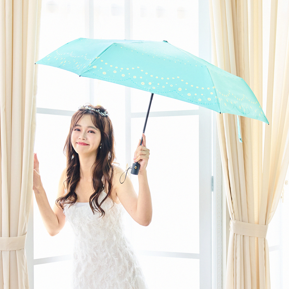 一位身穿連衣裙拿著環保紗降溫10℃自動傘水玉_水綠開心的笑著