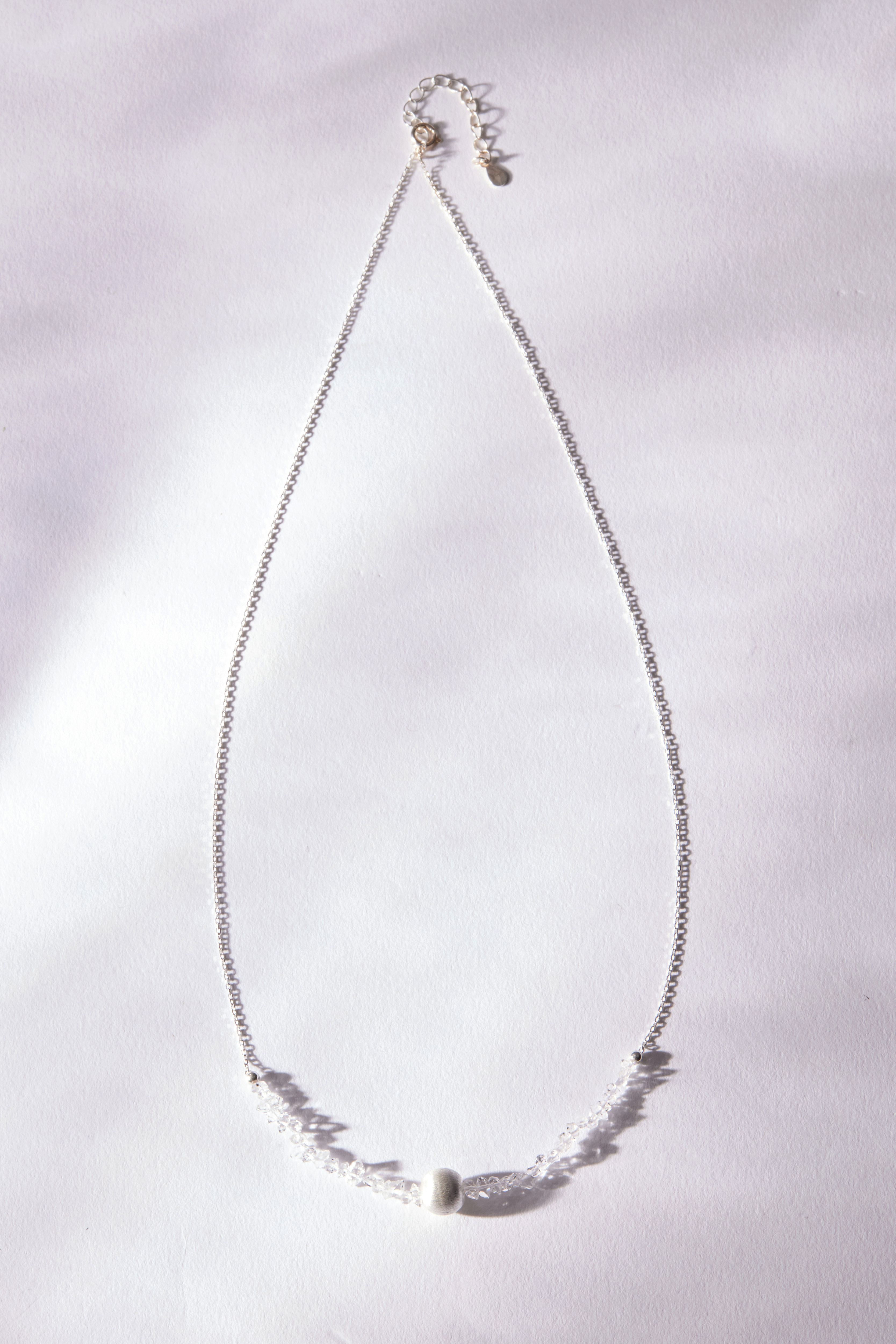 項鍊平放於白布面上，貓眼石柔和透亮，銀珠與鍊身細緻貼合。