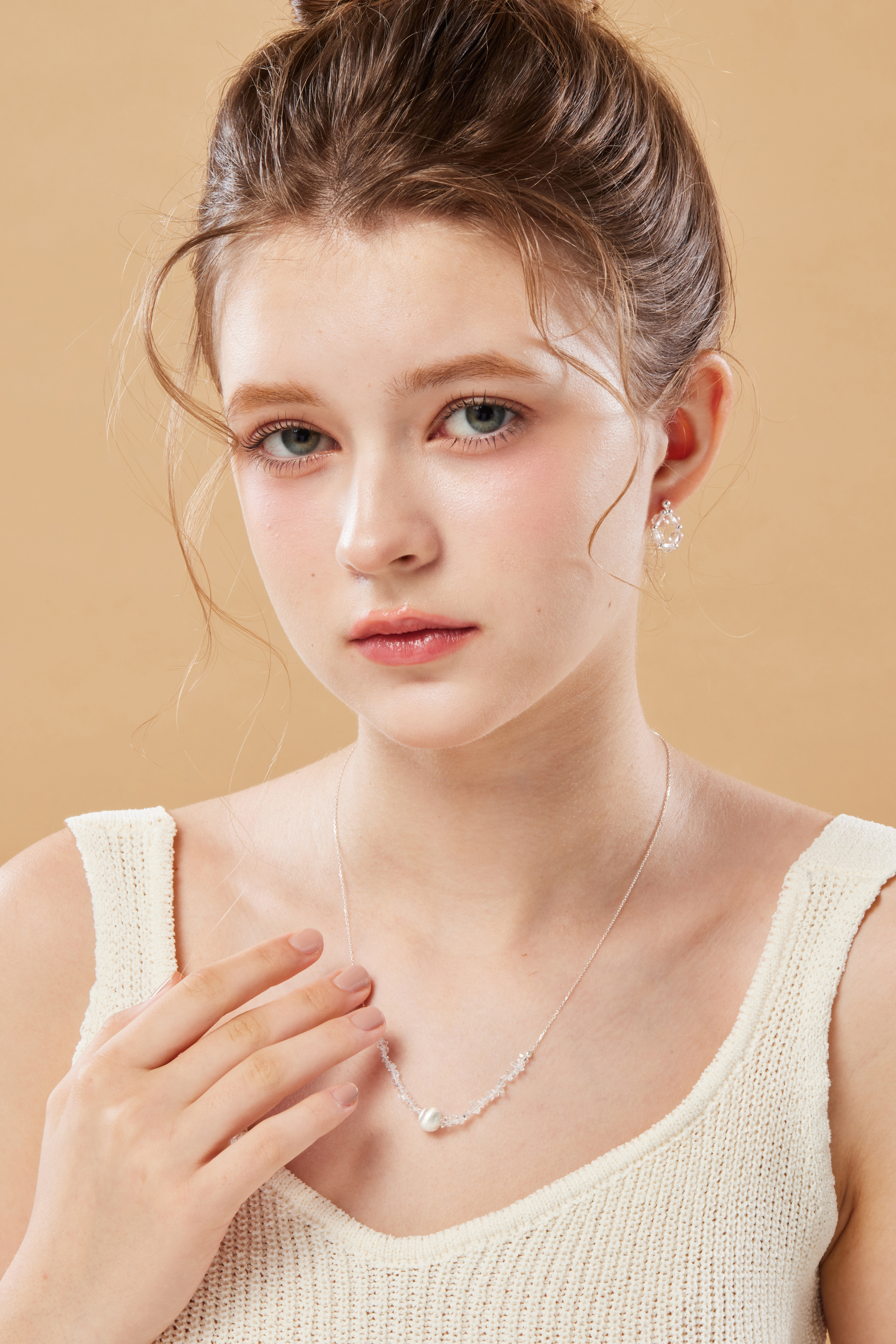 模特穿著素色上衣，項鍊搭配簡約穿搭，散發乾淨清新的氣質。