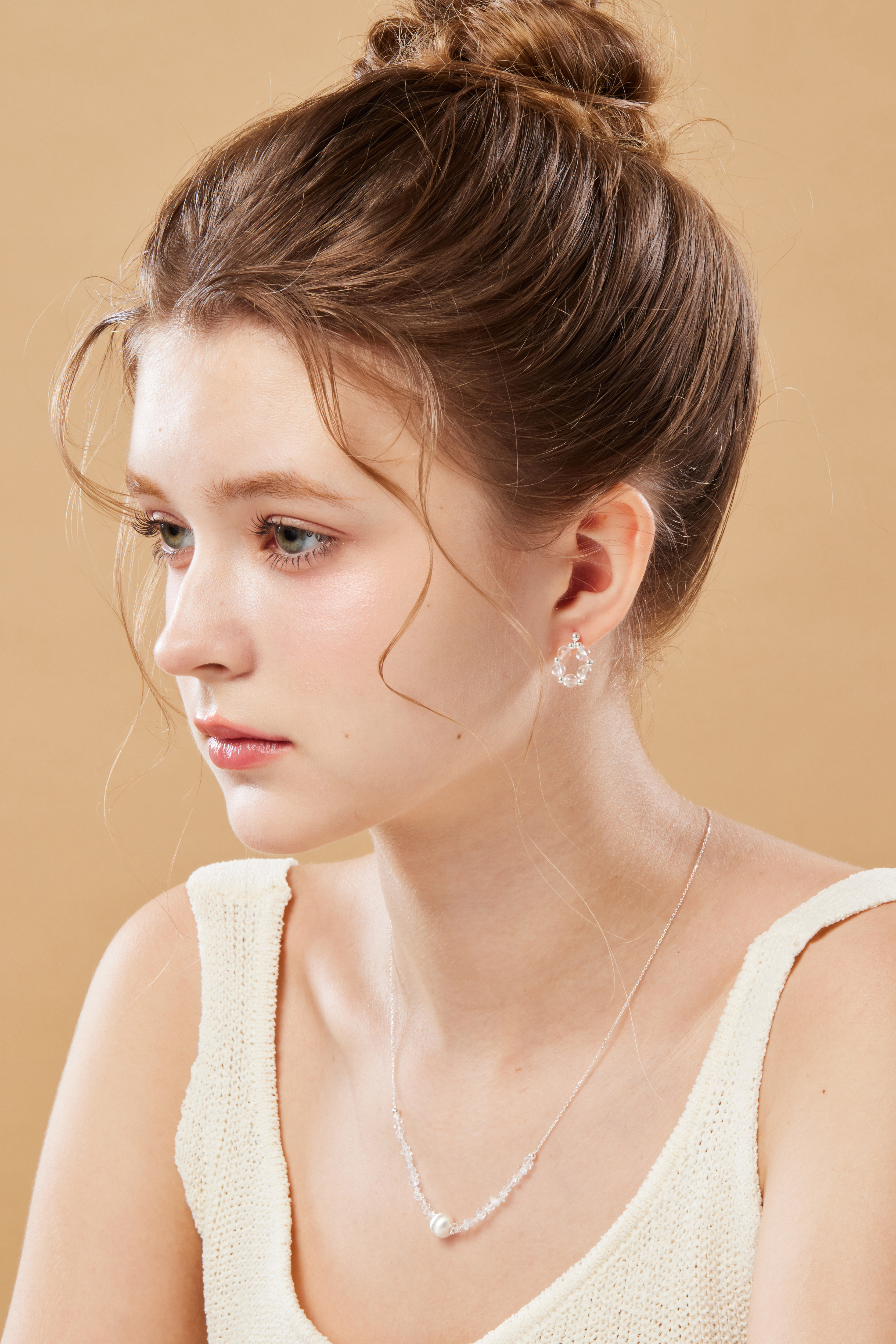 模特側臉看向遠方，項鍊與柔光共演簡約浪漫氛圍。