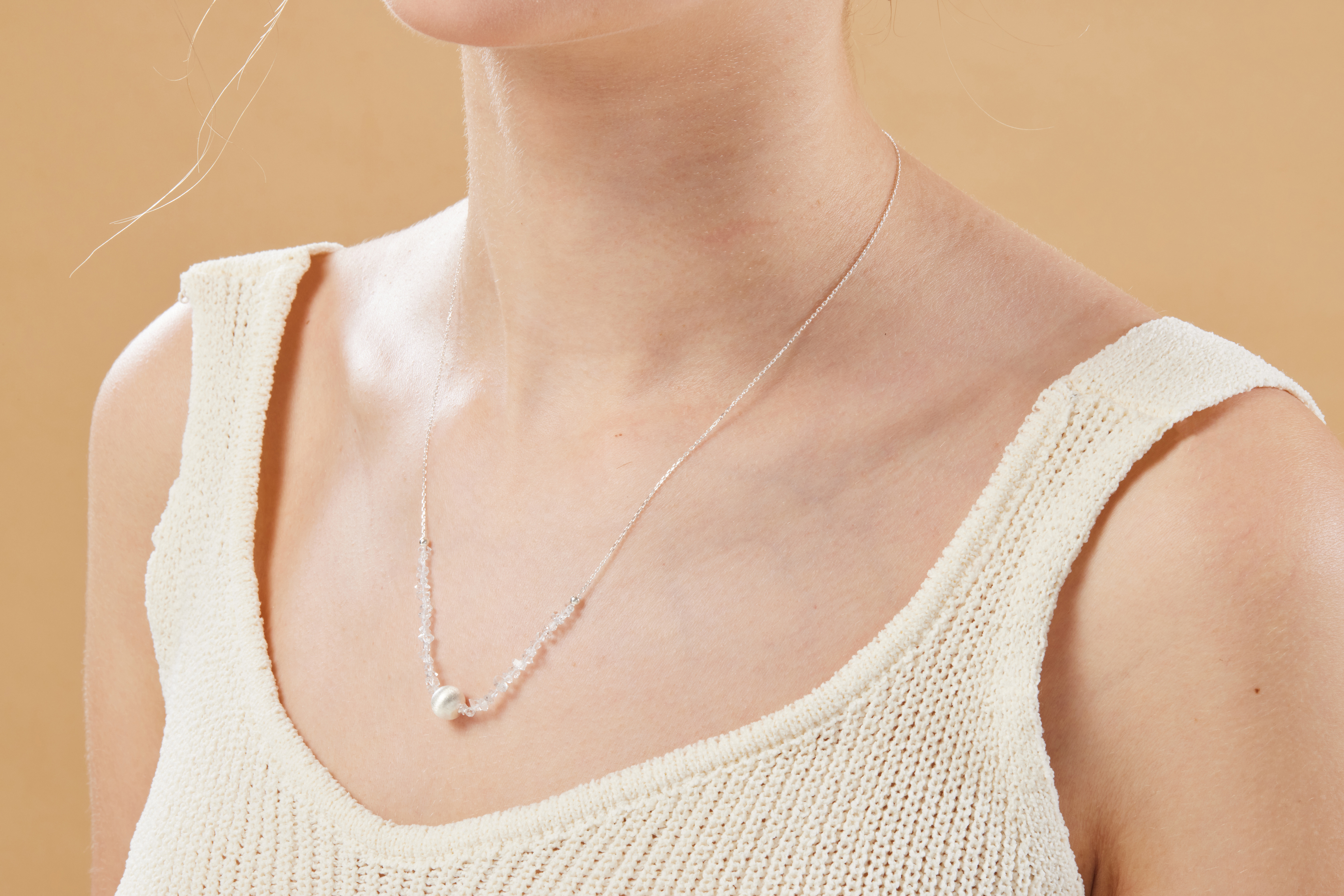模特頸部特寫，貓眼銀球項鍊貼合鎖骨，石面微微反光，展現清新氣質。