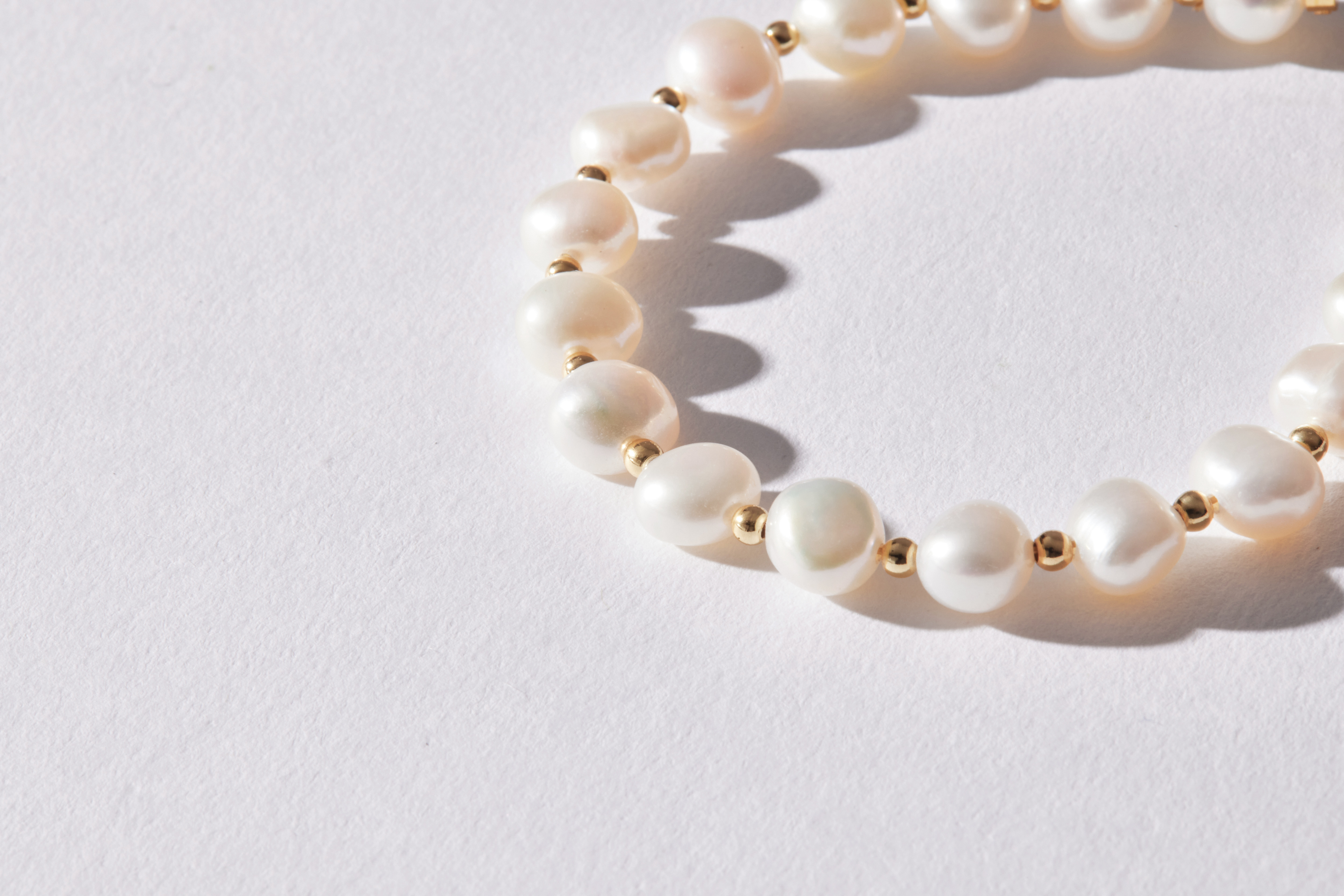 14kgf淡水珍珠手鍊近距離拍攝，珍珠自然排列，搭配金色小金球，展現細膩質感。
