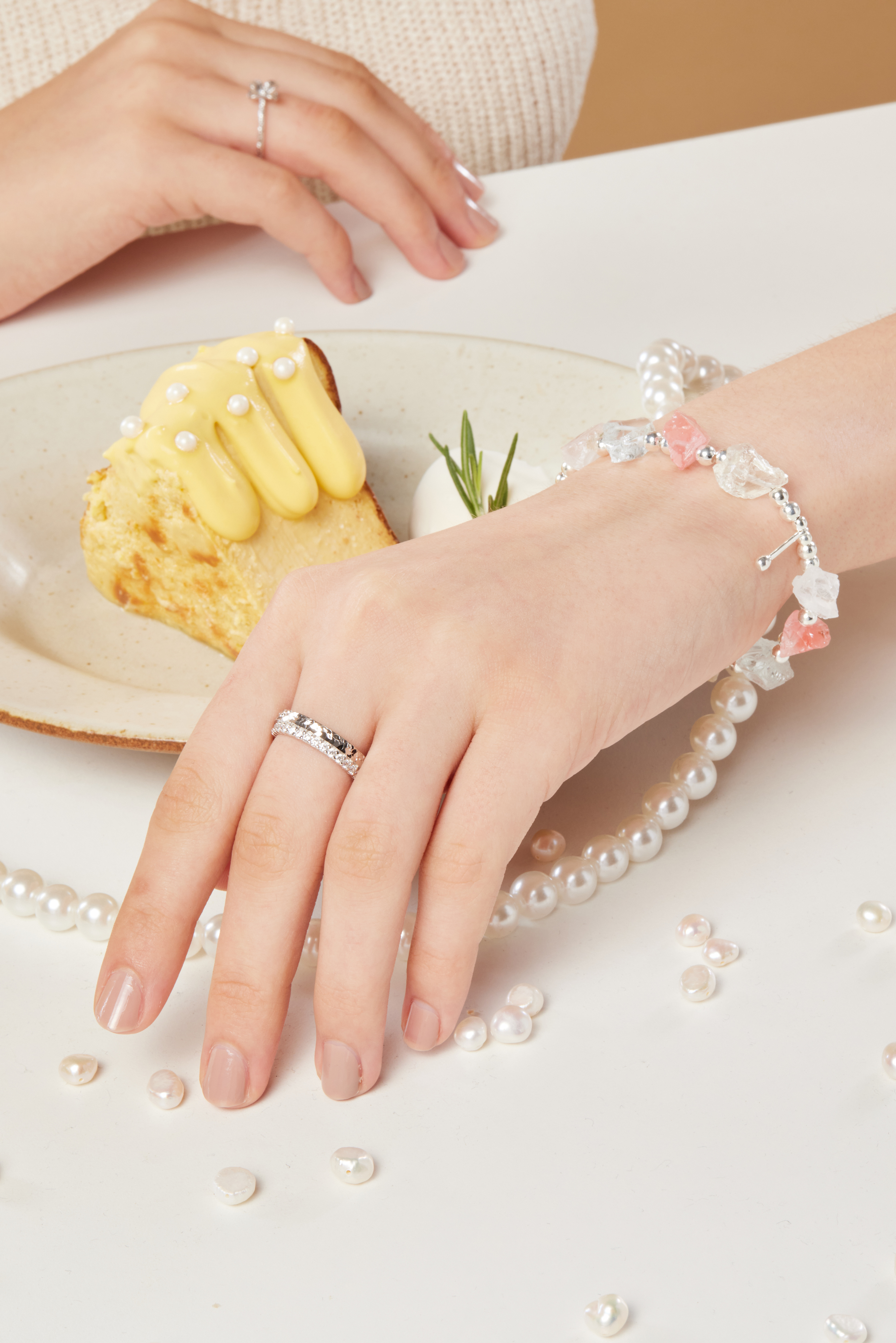 模特手指特寫，閃亮鋯石戒指佩戴於指間，鋯石在光線下閃爍清透光澤，指尖精緻迷人。