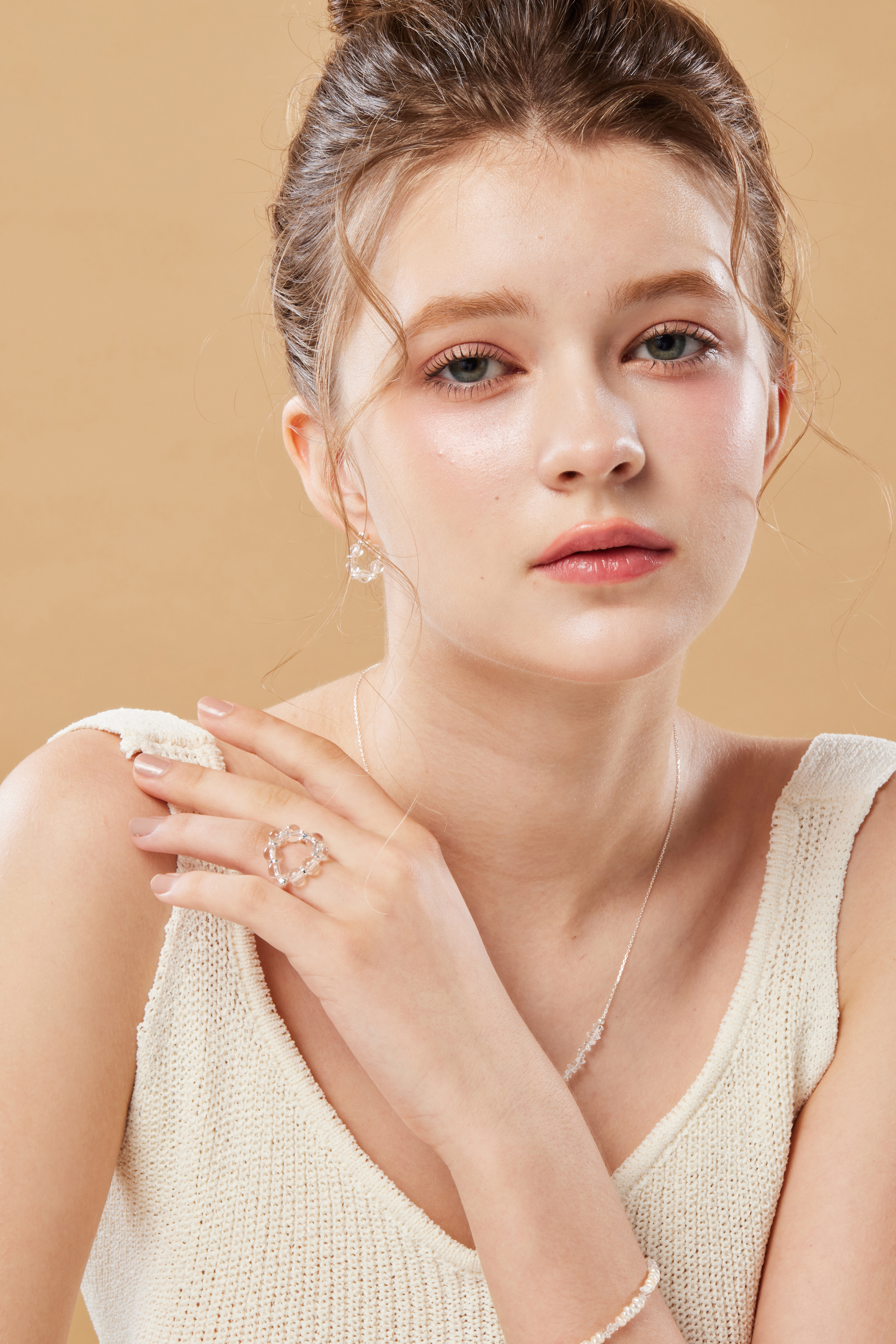 模特左手搭右肩，戒指成為視覺焦點，畫面溫暖甜美。