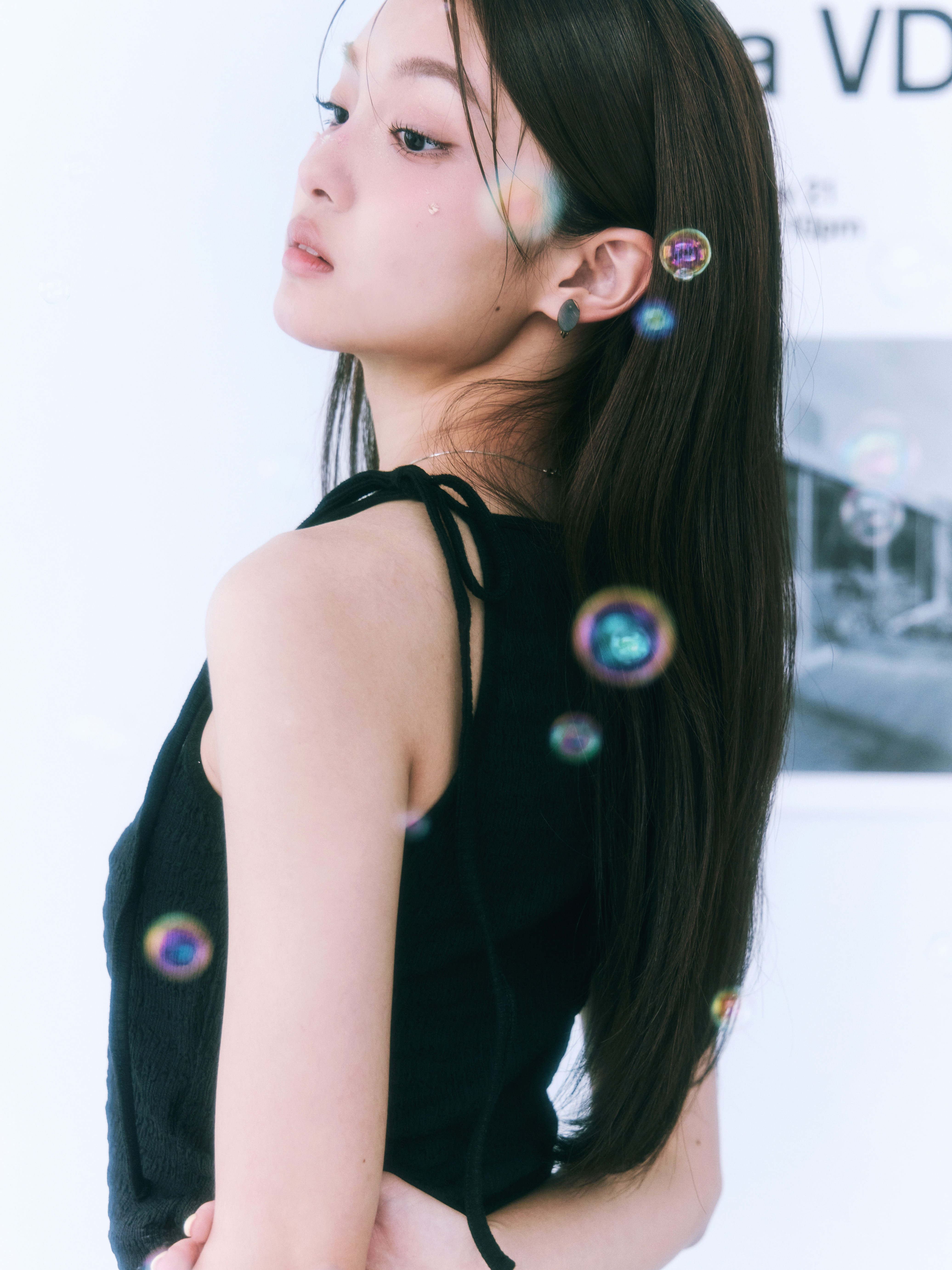 女孩側著臉穿著單邊綁帶的背心，並且背心表面有皺皺紋理