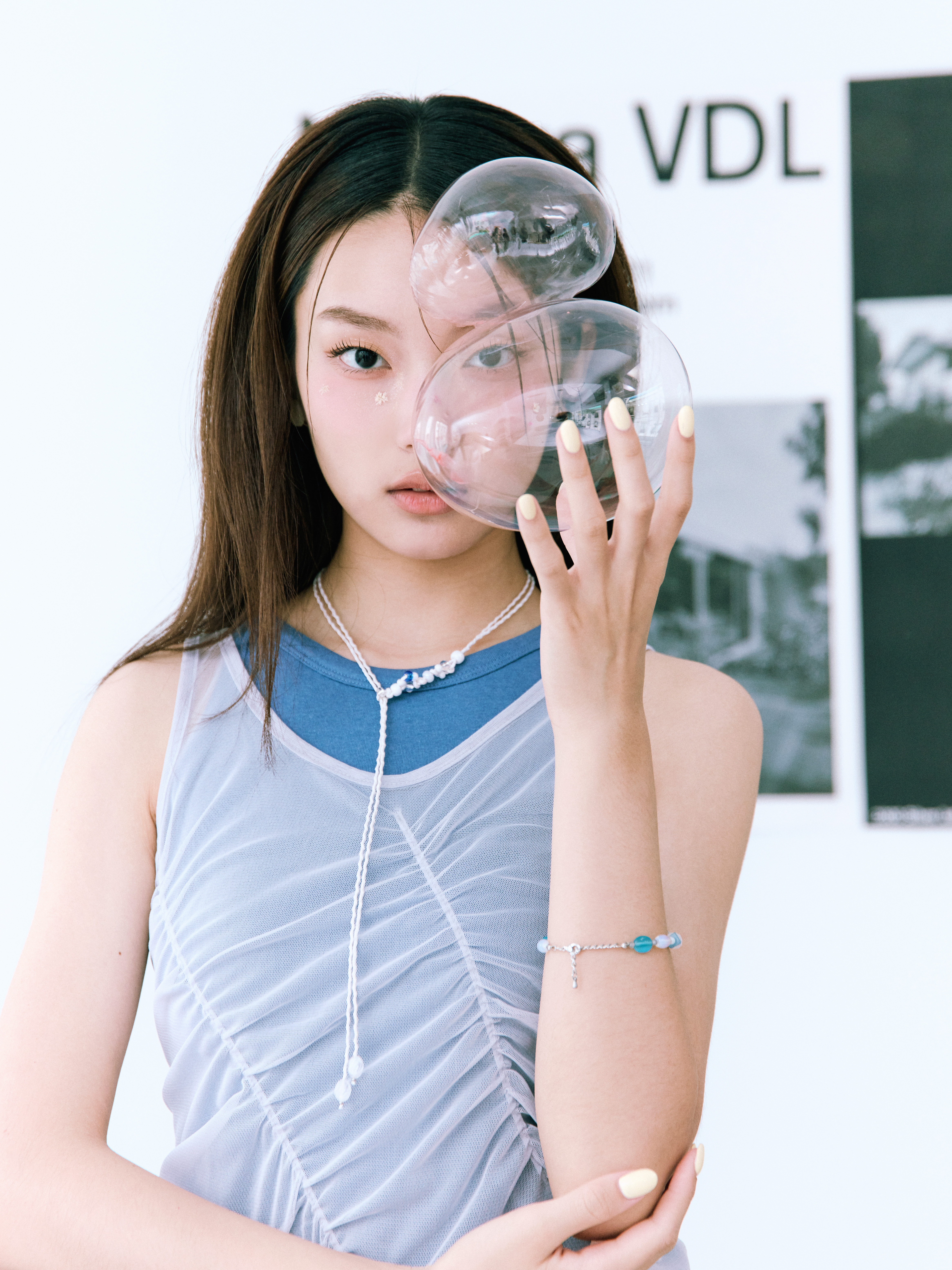 女孩拿著泡泡身穿藍色坦克背心疊穿淺灰抓皺透紗背心，很協調又亮眼的配色