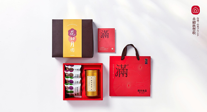 花好月圓2025中秋禮盒組，在白色背景上，中秋禮盒內放著四包堅果酥與用金色茶葉罐裝的蕎麥茶，旁邊搭配紅色手提紙袋與滿字賀卡。