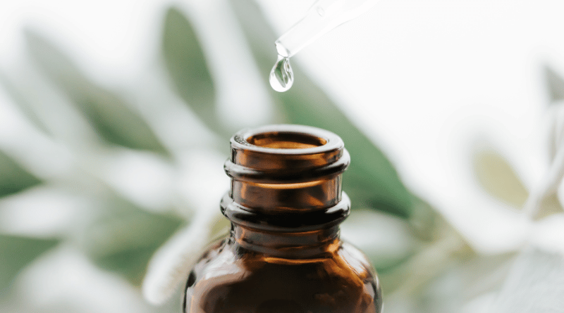 精油滴入玻璃瓶的特寫：精油滴入深色玻璃瓶中，象徵天然芳療的純粹與濃縮能量