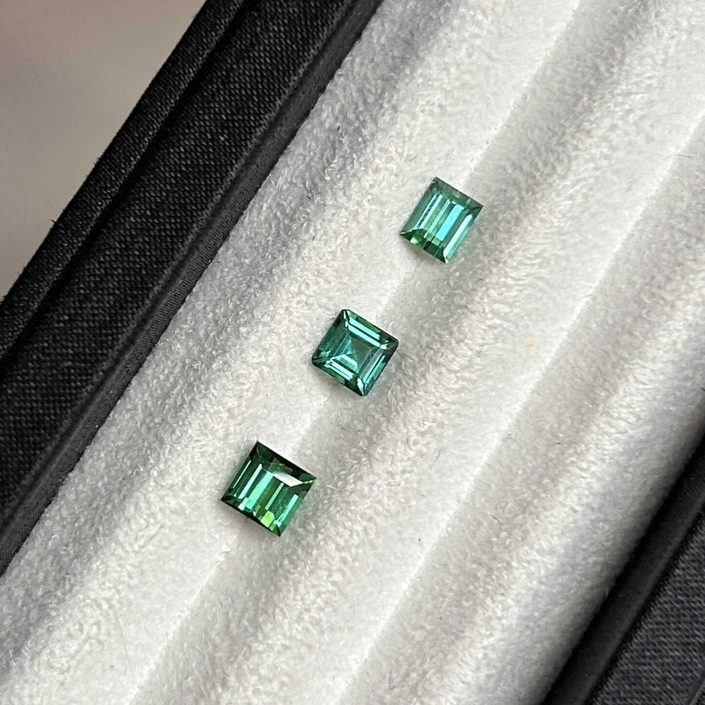 Three natural Lagoon tourmalines in square emerald cut, weighing 0.58 ct, 0.59 ct, and 0.96 ct from top to bottom.