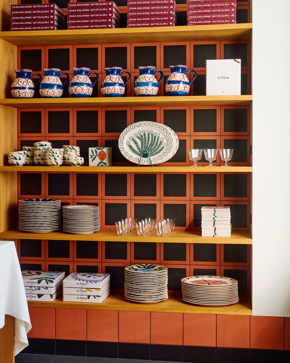 餐廳的層架內擺放著各種尺寸和樣式的 HAY LA Pittura 系列餐具，品味滿分