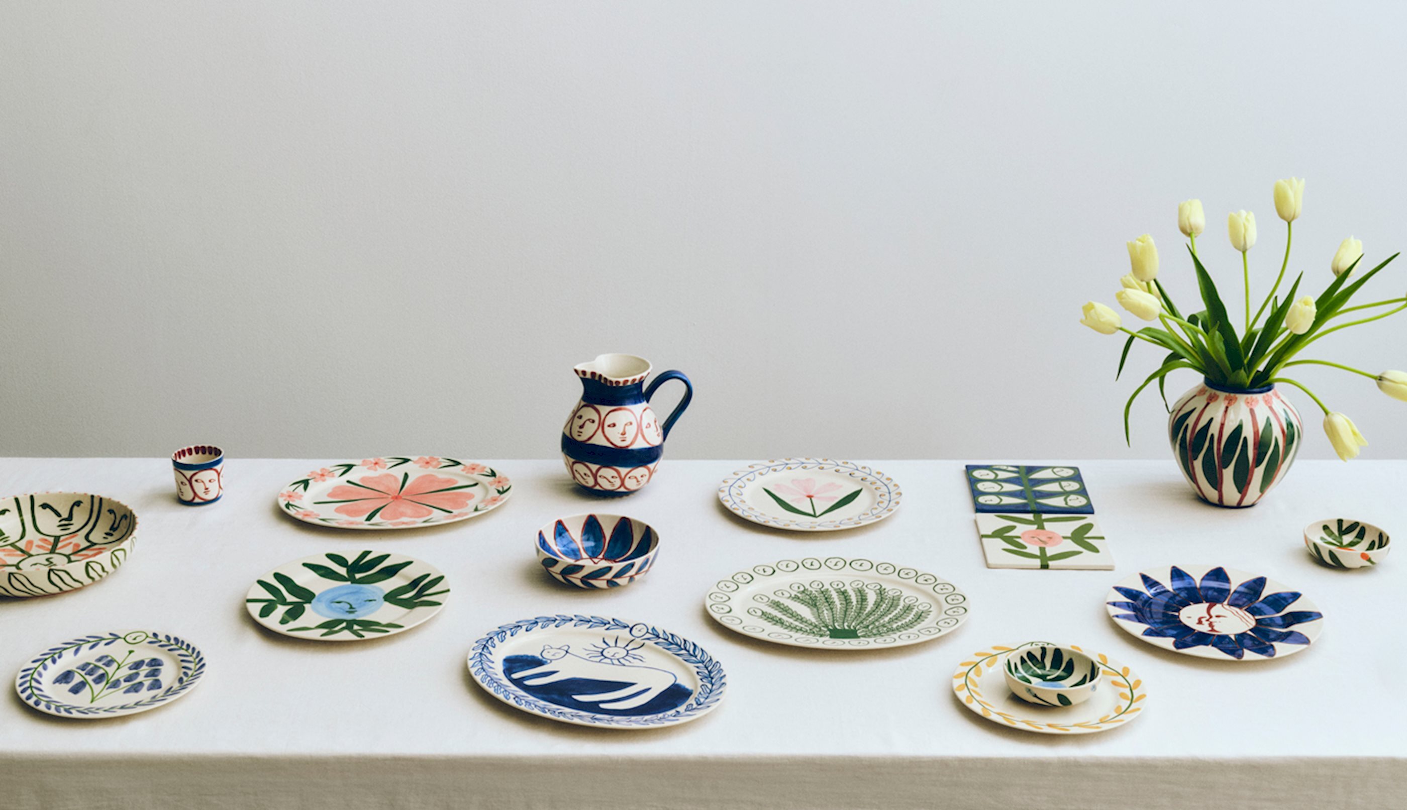 HAY LA piturra系列餐具擺放在桌上，包含陶瓷手繪盤子、花瓶、水壺、飯碗、隔熱墊