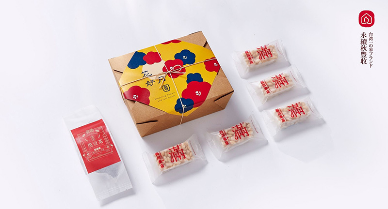 西川米店的純素中秋伴手禮，純白背景中放著上面有印花好月圓的環保牛皮盒包裝、印著喜氣紅滿字的5個米香點心，以及1包貼著喜氣紅色標籤的黑豆茶