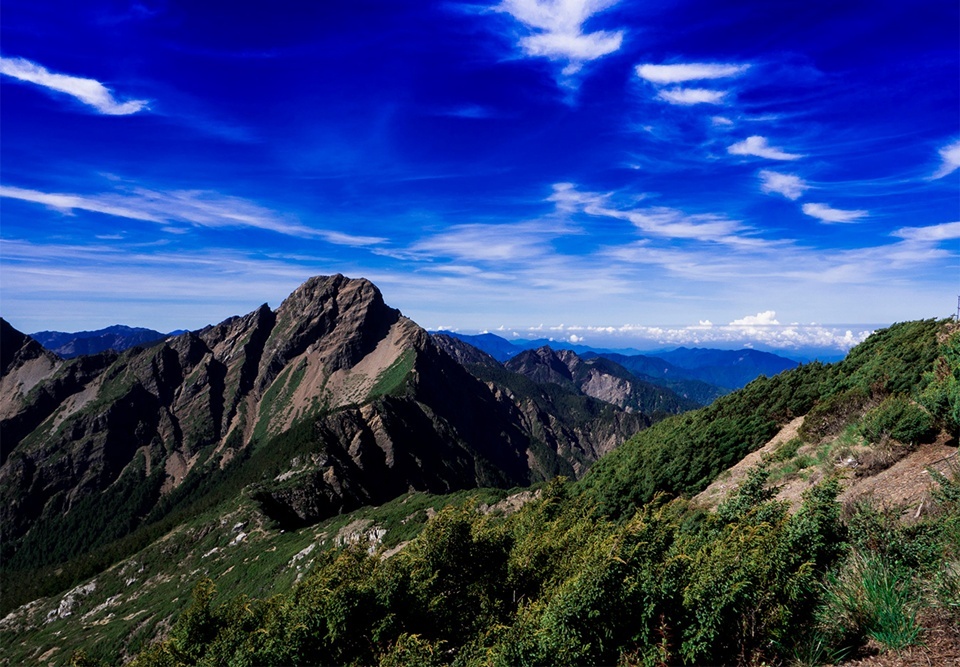 站在玉山主峰近 4,000 公尺的高度，四周群峰環繞，視野沒有任何遮擋，宛如置身在天地的中央。