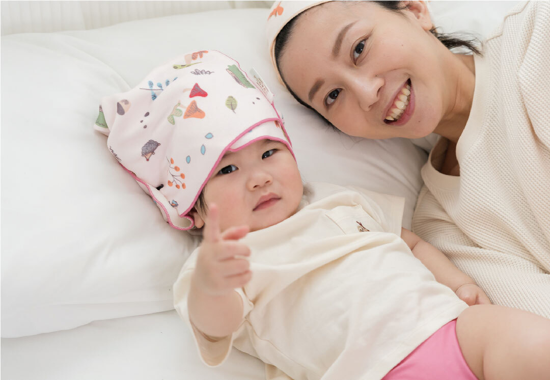 小孩包著兒童吸水毛巾躺在床上