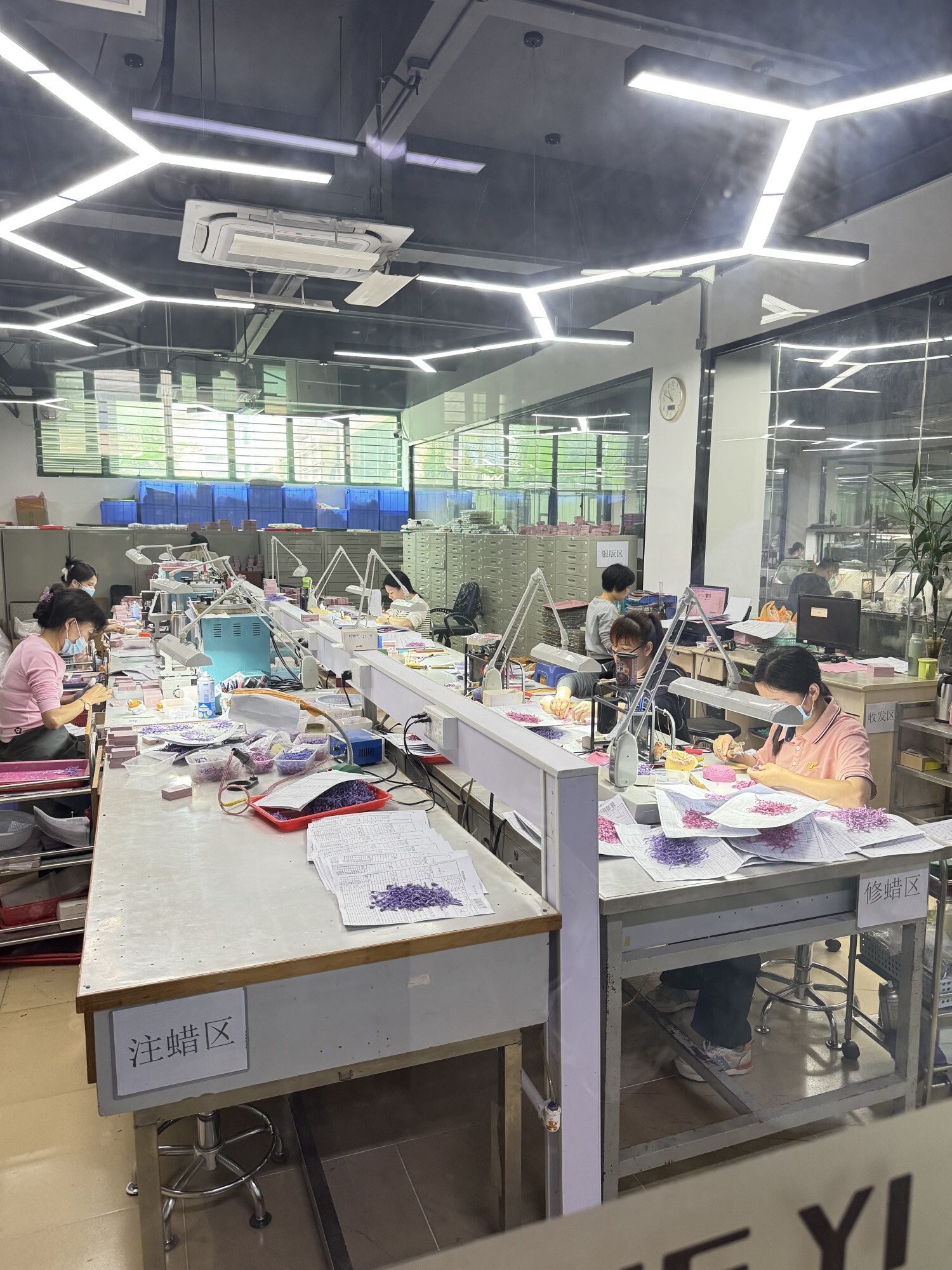Técnicos trabajando en mesa de producción con acabados de alta precisión; soporte para modelos de cooperación OEM y ODM